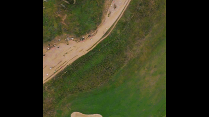 Vue aérienne d'une plage, avec un sentier en sable et des zones de végétation