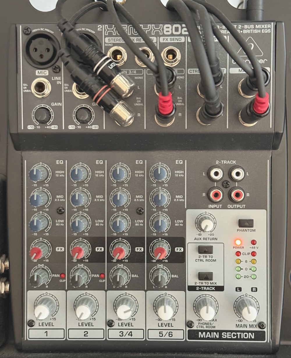 Audio mixer with multiple input and output ports, sliders, and knobs for adjusting sound levels and effects.
