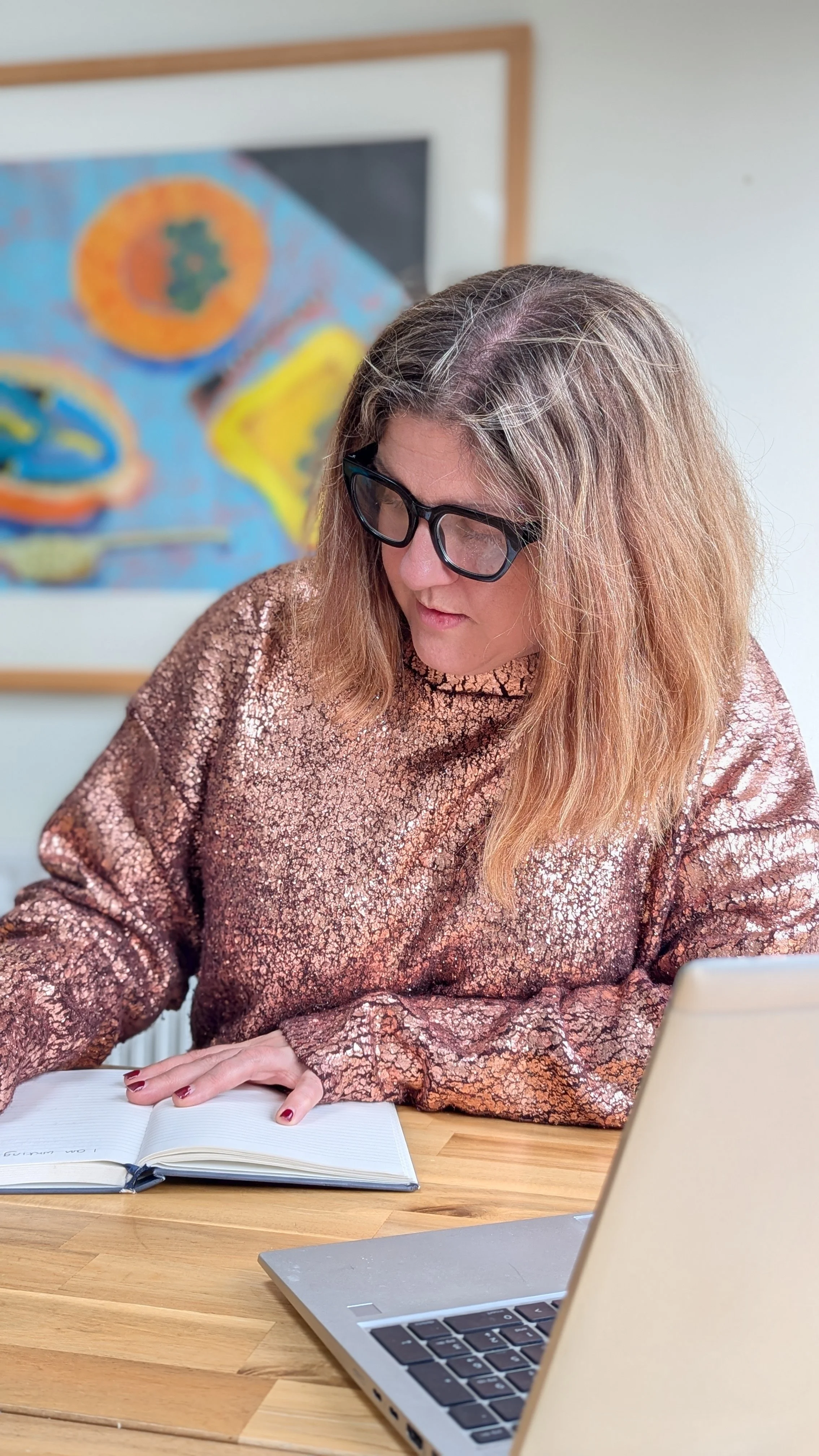 A photo of Jess Parker in dark glasses, working at a desk