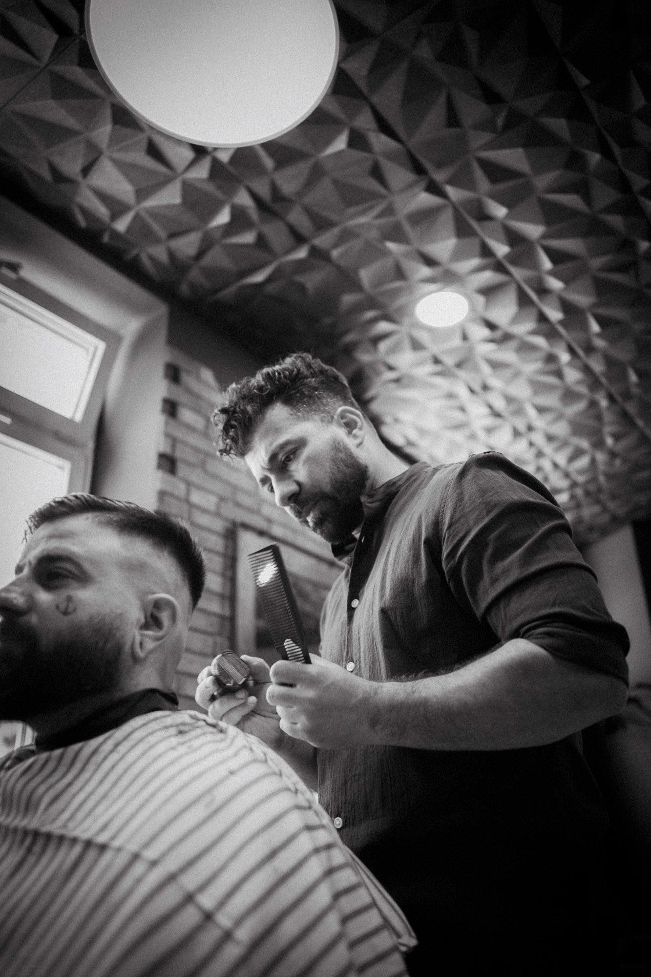 Mann erhält einen Haarschnitt in einem Barbershop, schwarz-weiß Foto.