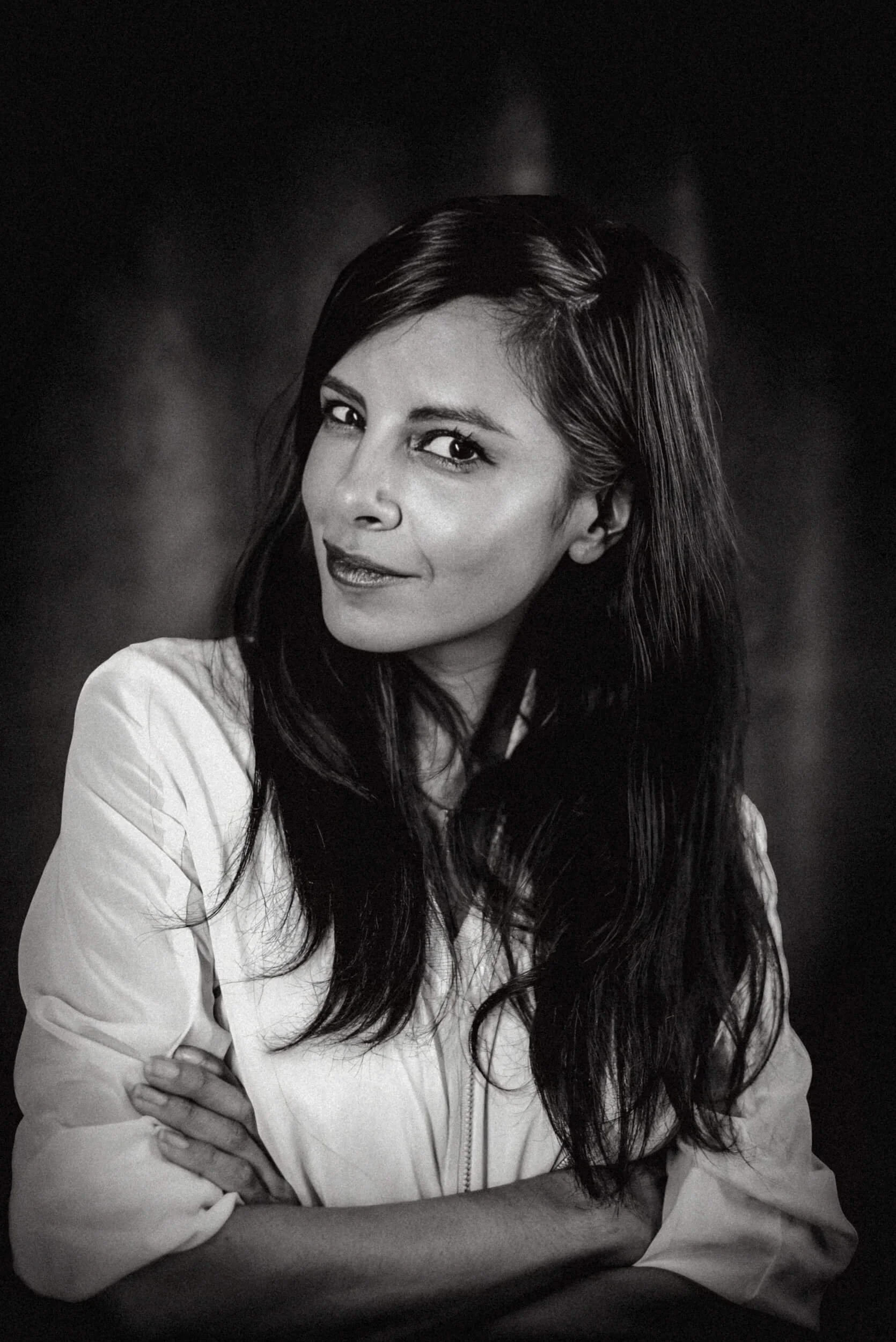 Portrait von Moderation Collien Fernandes mit dunklem Haar, gekleidet in eine helle Jacke, die die Arme verschränkt hat.