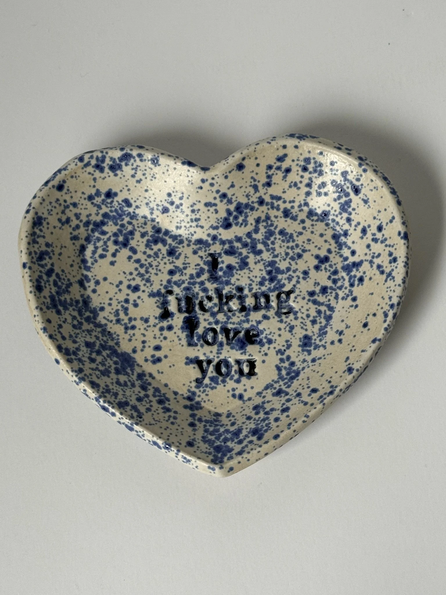 Heart-shaped ceramic dish with blue speckles and the words 'I like you' inscribed in the center.