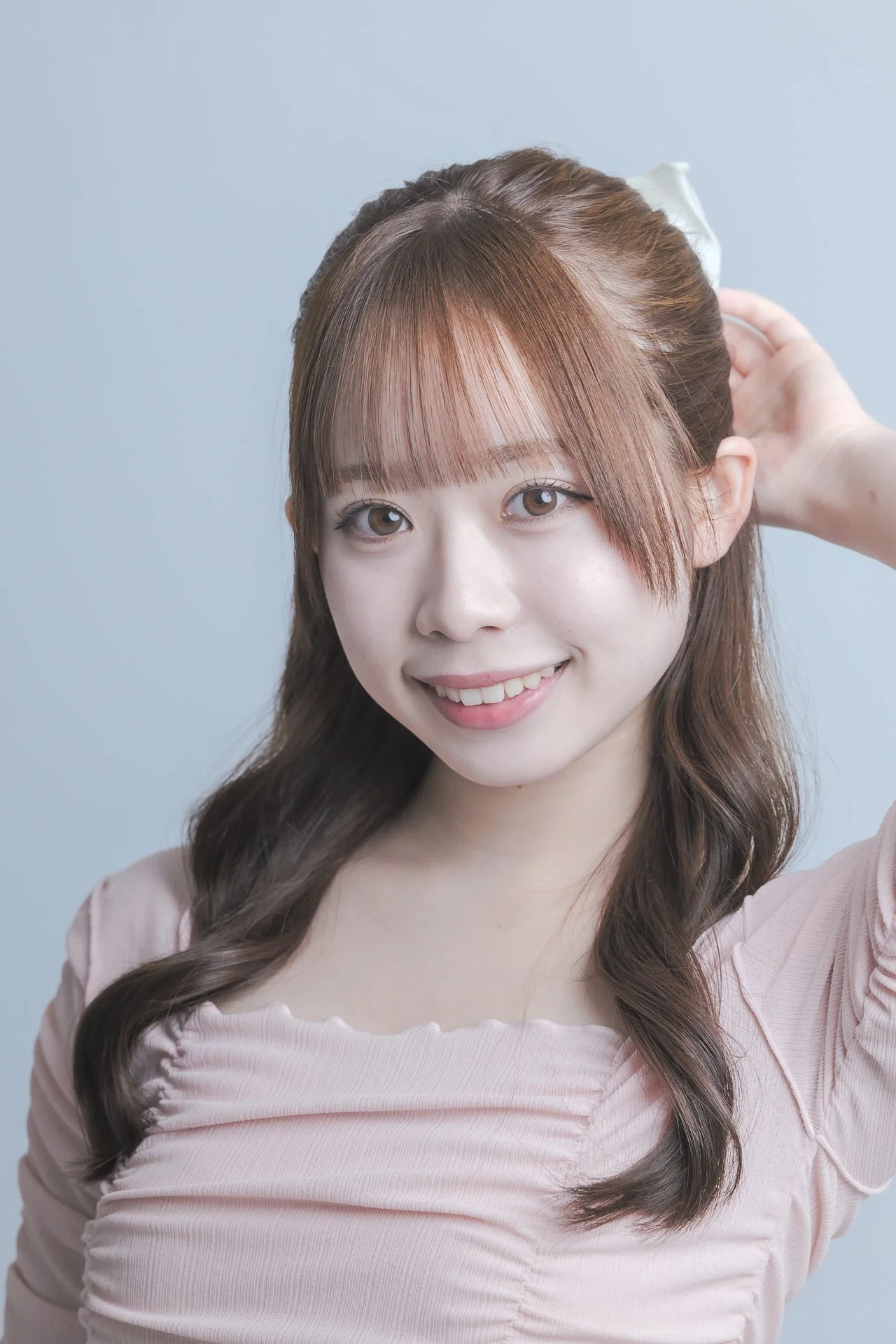 笑顔の若い女性が髪を直している写真