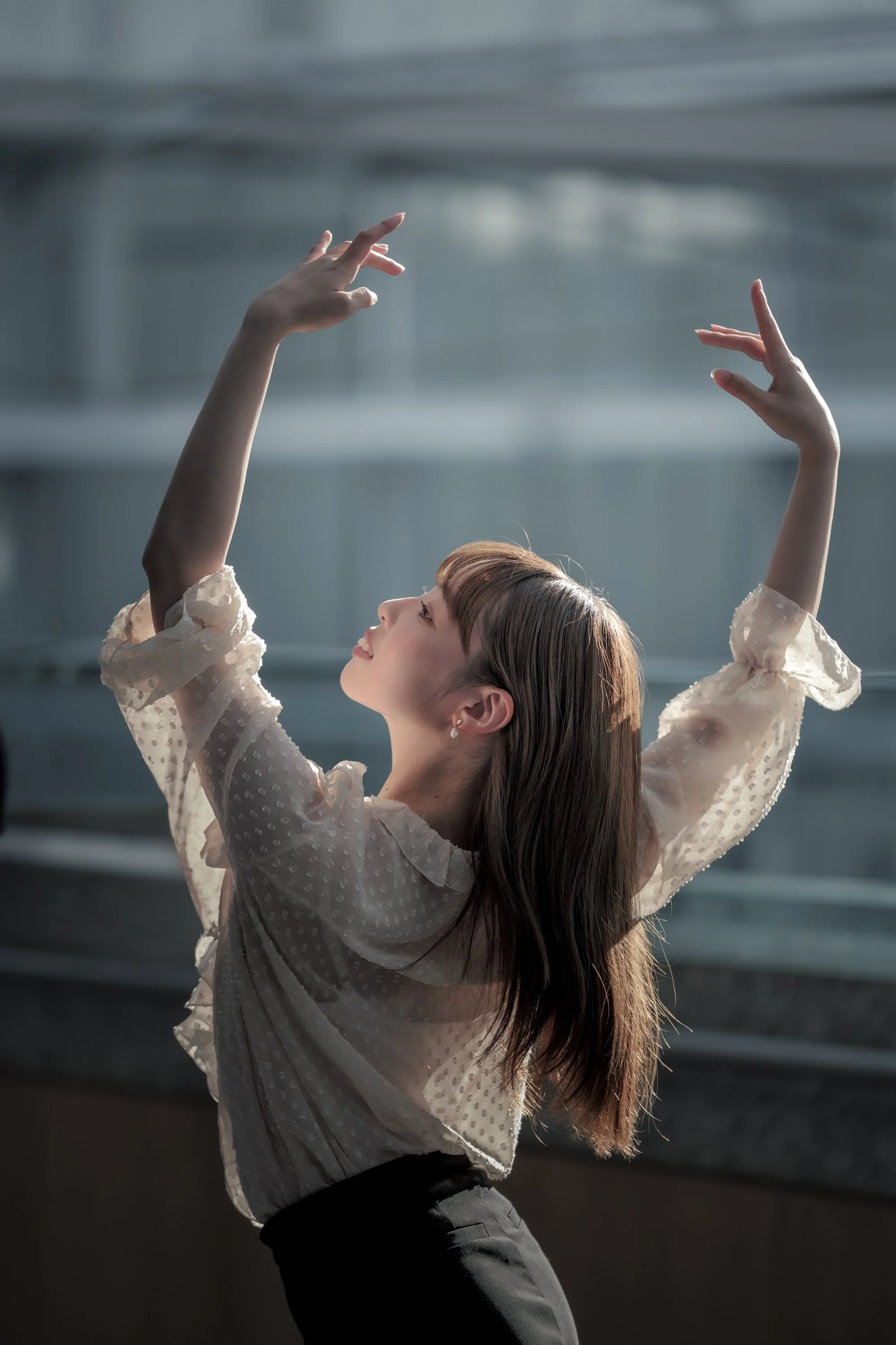 ガラス越しに踊る女性の横顔と手のアップ