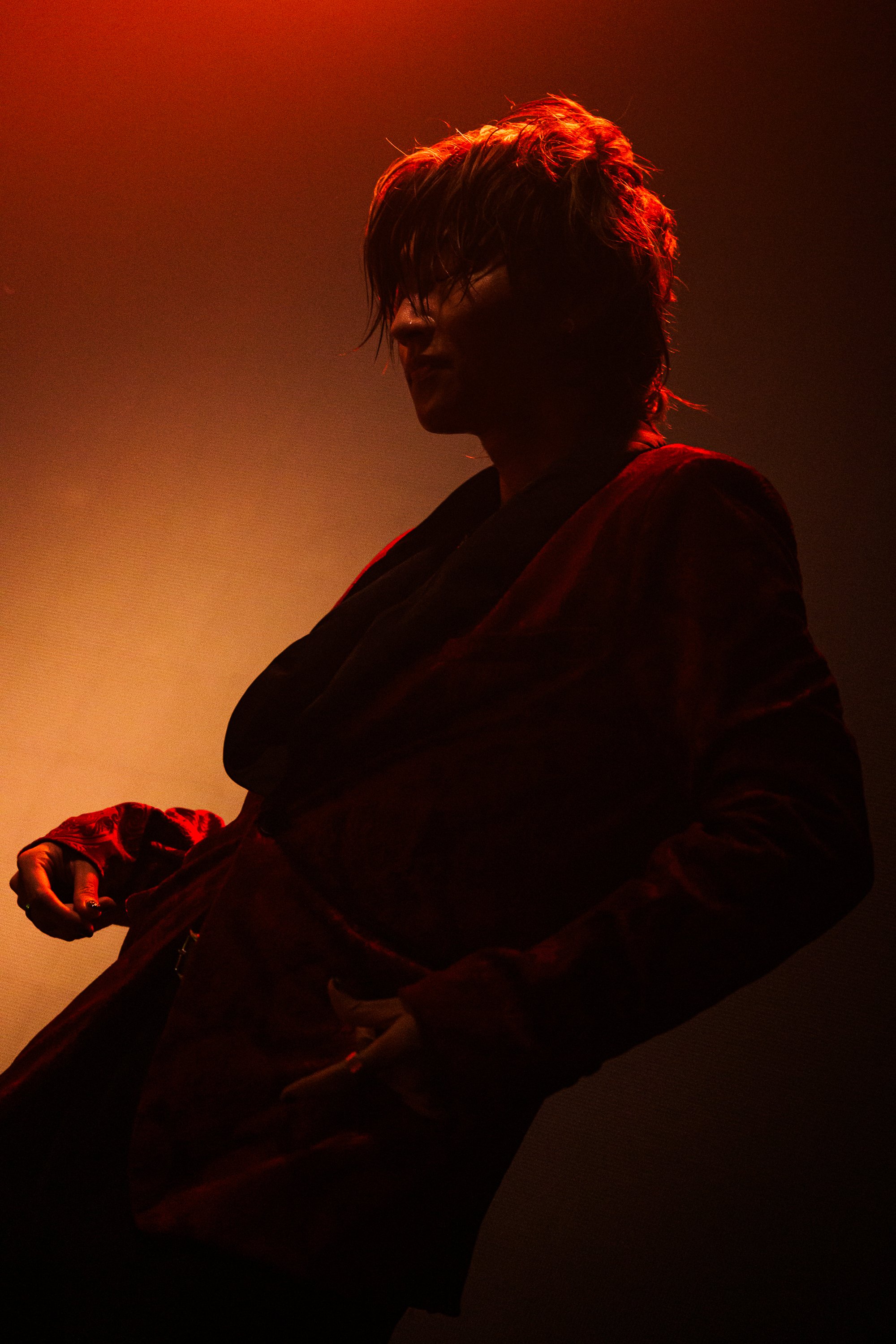 赤い照明の下でポーズをとる男性のシルエット写真