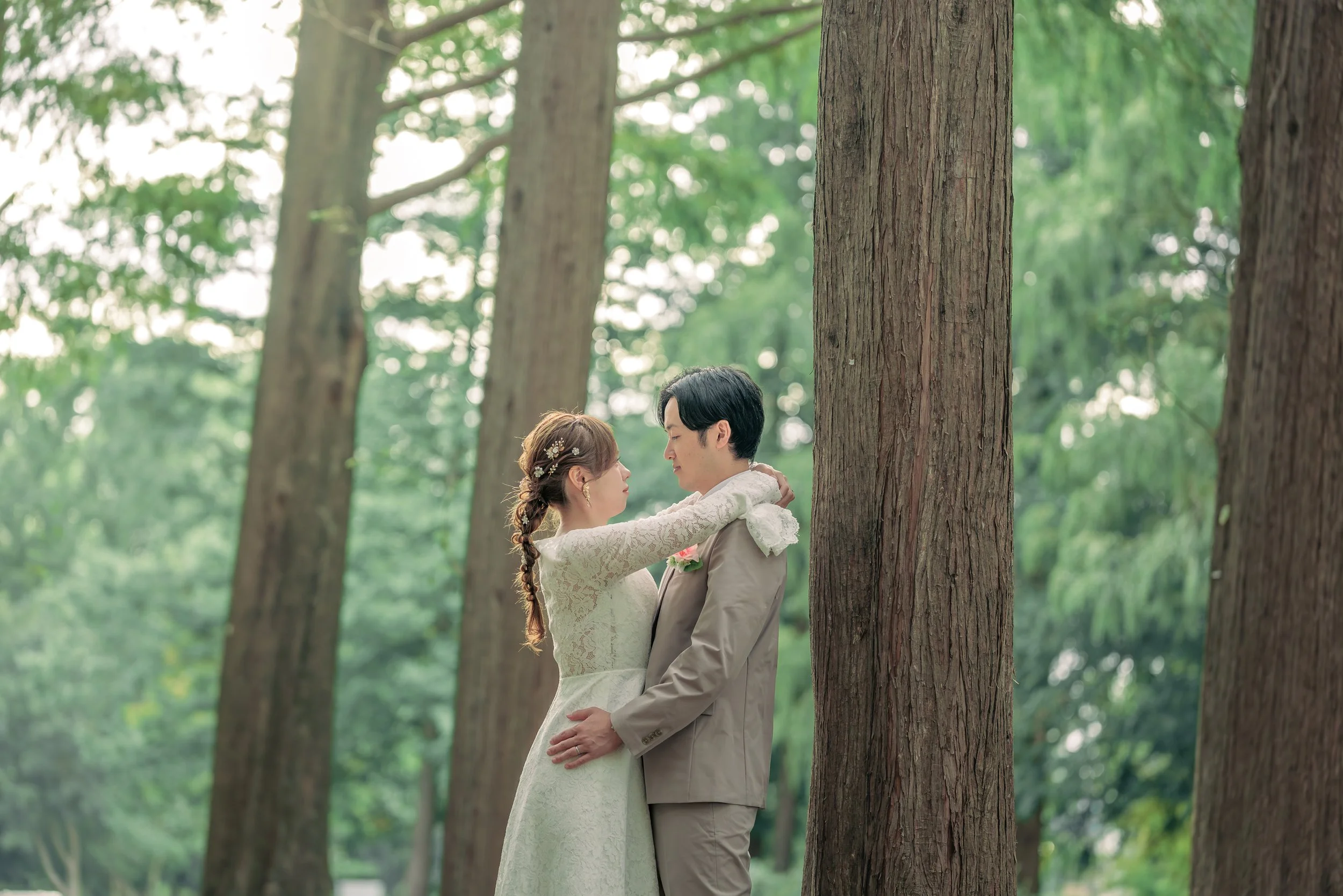 森林の中で手をつなぎ見つめ合う新郎新婦。