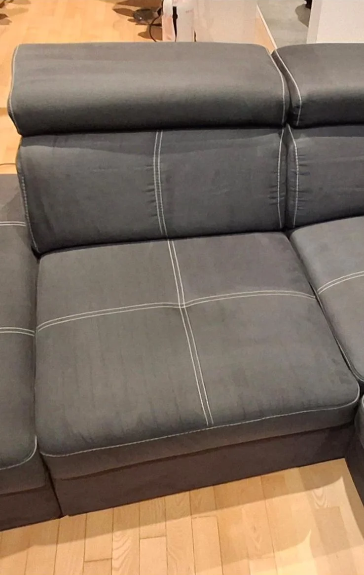Siva sofa od tkanine s bijelim šavovima i prilagođenim presvlakama