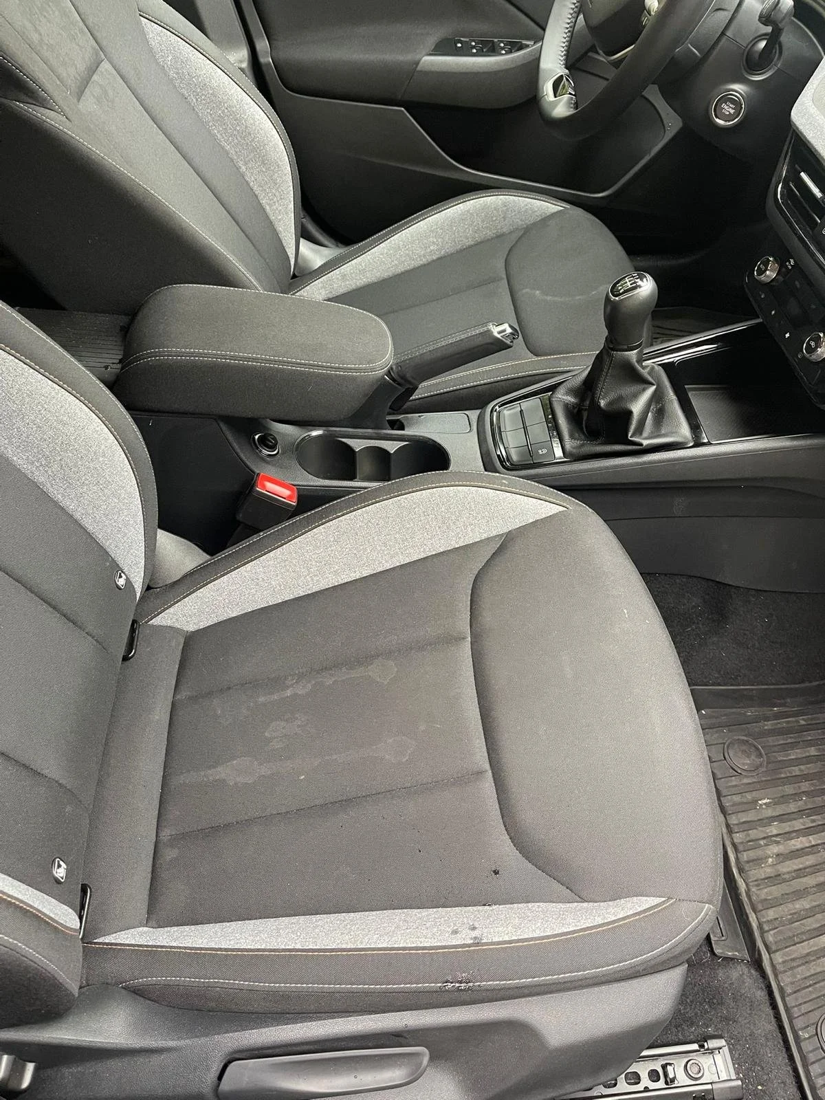 Unutrašnjost automobila s vozačkim i suvozačkim sjedalom, središnjom konzolom i mjenjačem