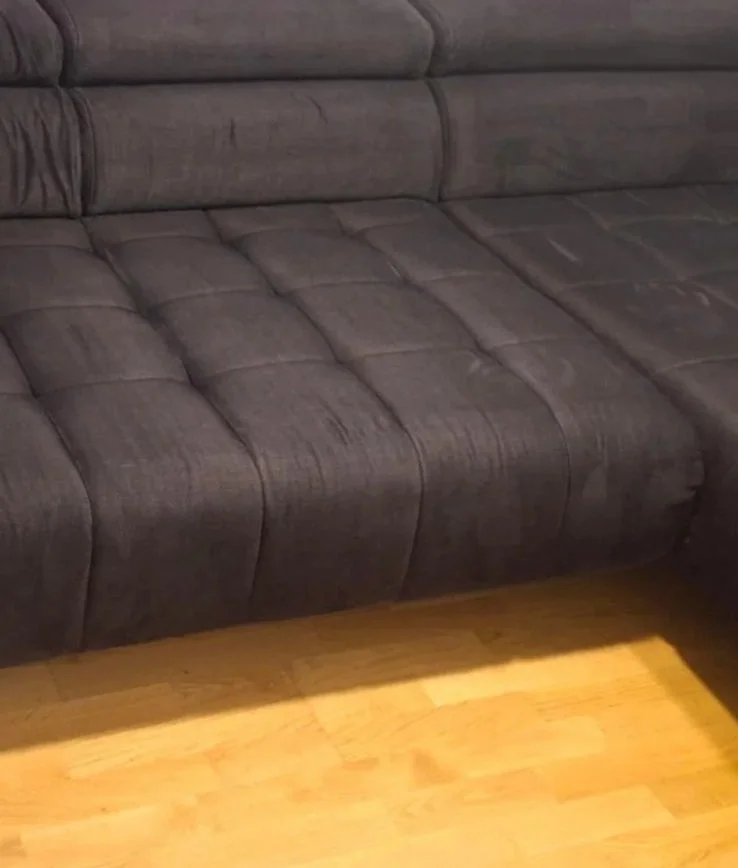 Tamnosiva dubinski očišćena kutna garnitura s prošivenim dizajnom na drvenom podu