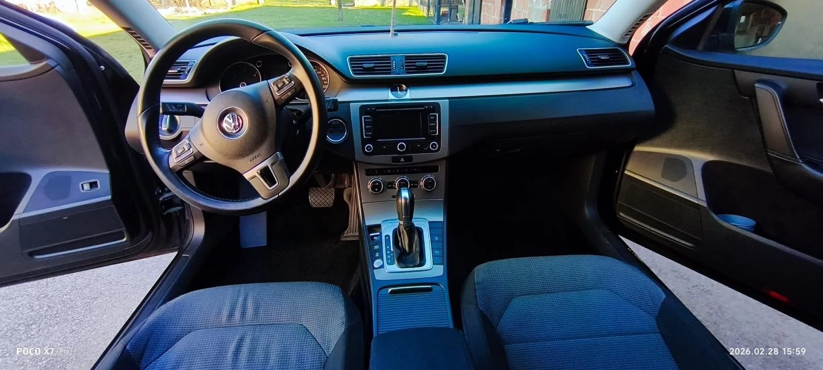 Interior of a modern Volkswagen car showing the steering wheel, dashboard with digital display, center console with gear shift, and front seats.