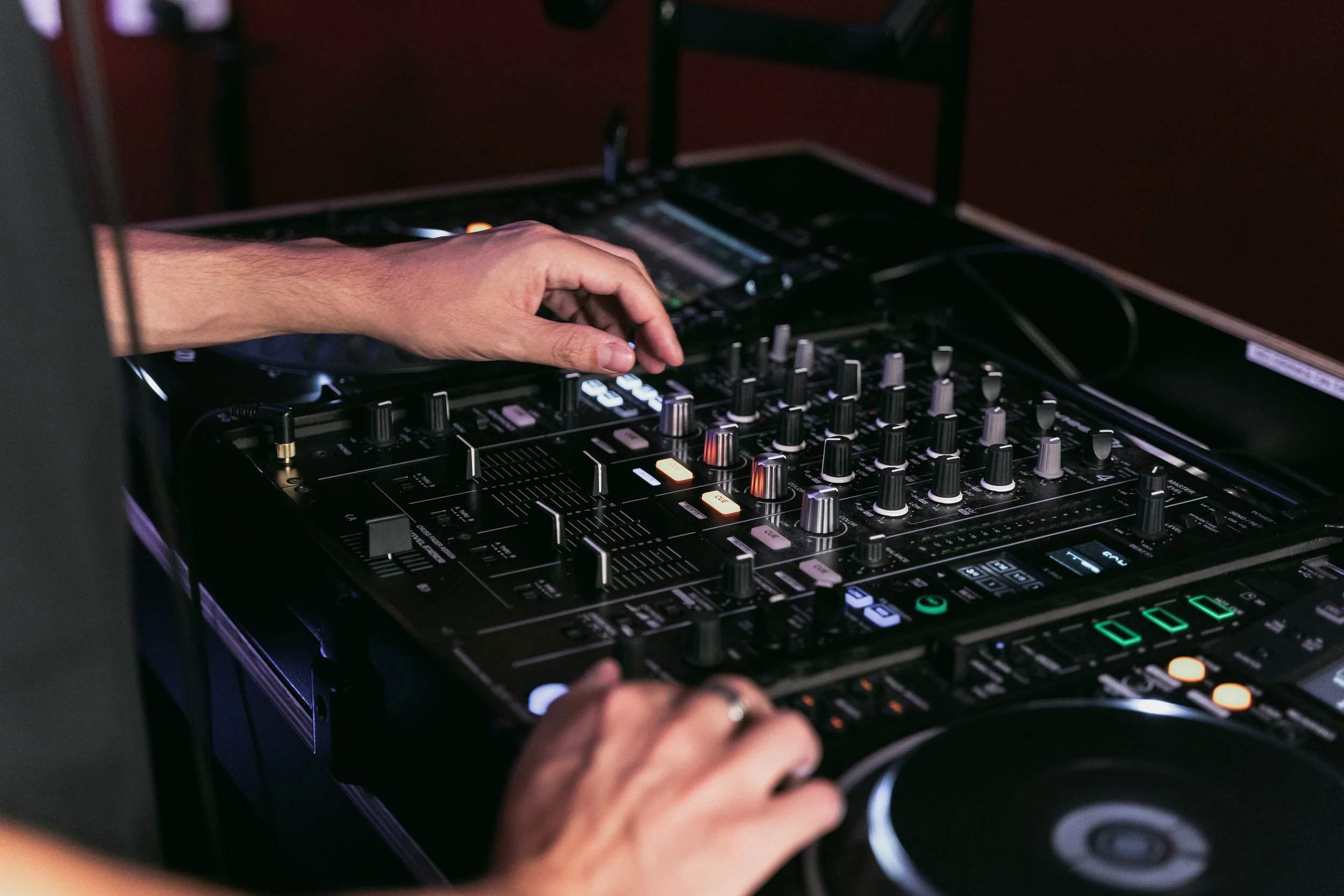 Close-up of DJ TROV mixing live music on professional DJ decks at a Perth event