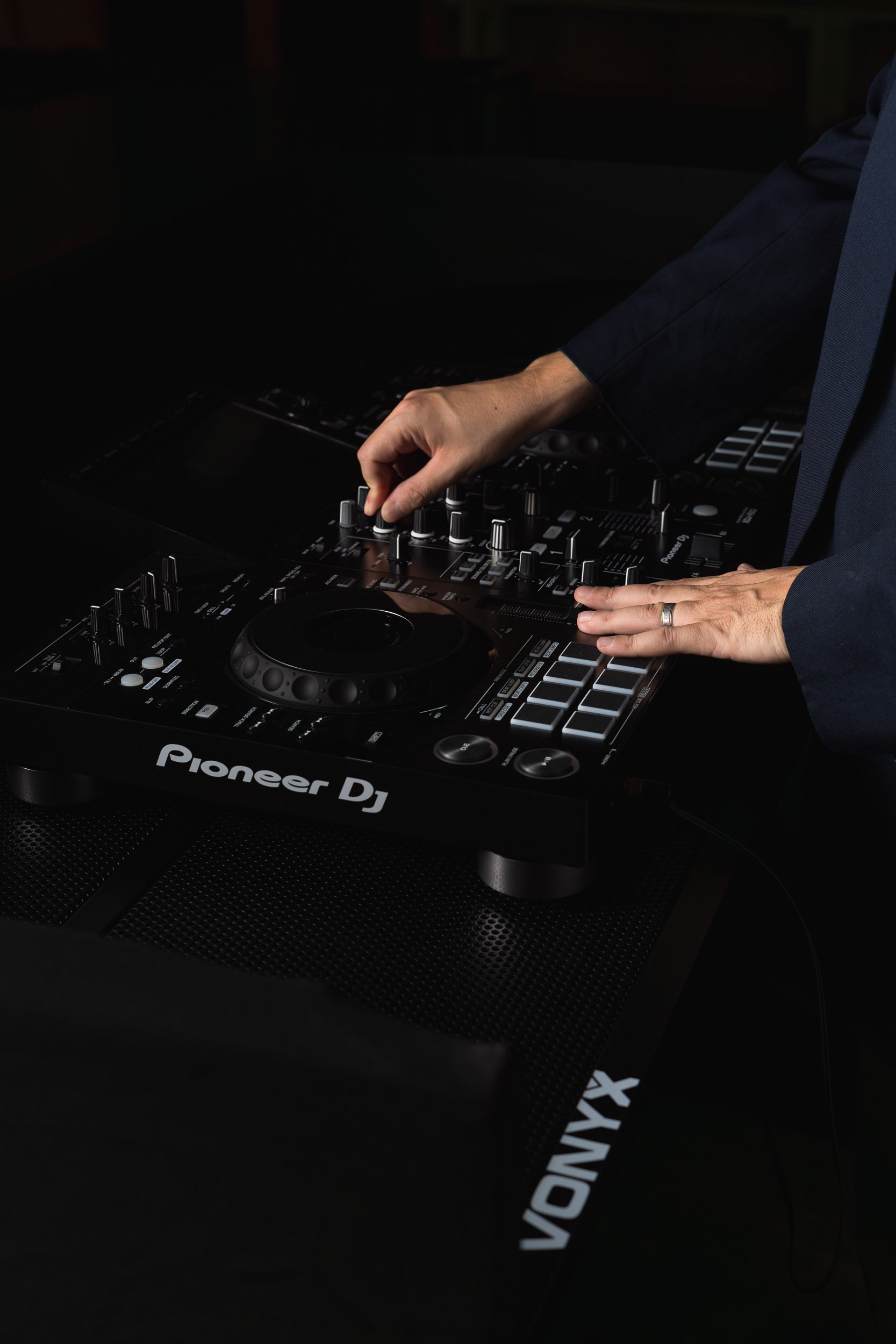 Close-up of DJ TROV mixing live music on professional DJ decks at a Perth event