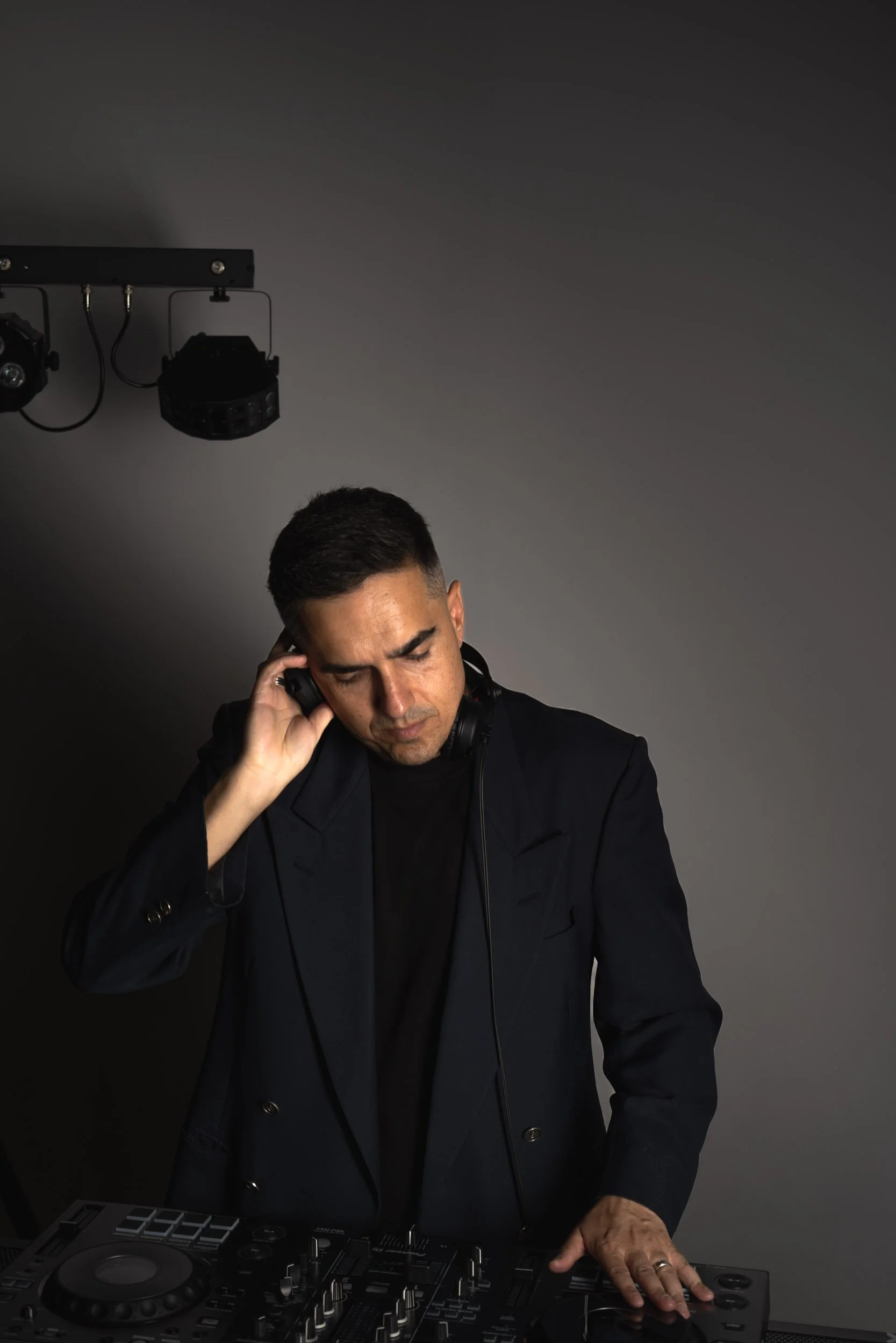 DJ TROV performing at a wedding in Perth, wearing headphones and mixing on professional DJ decks