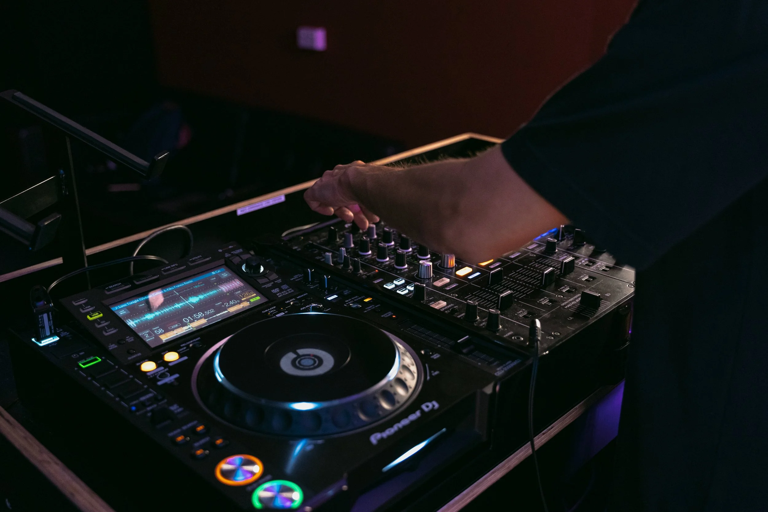 Close-up of DJ TROV mixing live music on professional DJ decks at a Perth event
