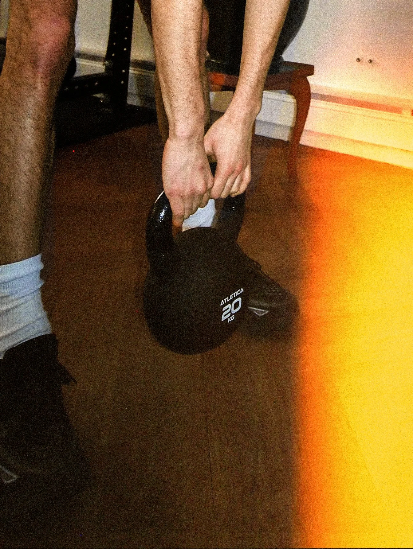 Analoge Blitzaufnahme von jemandem, der eine Kettlebell hält.