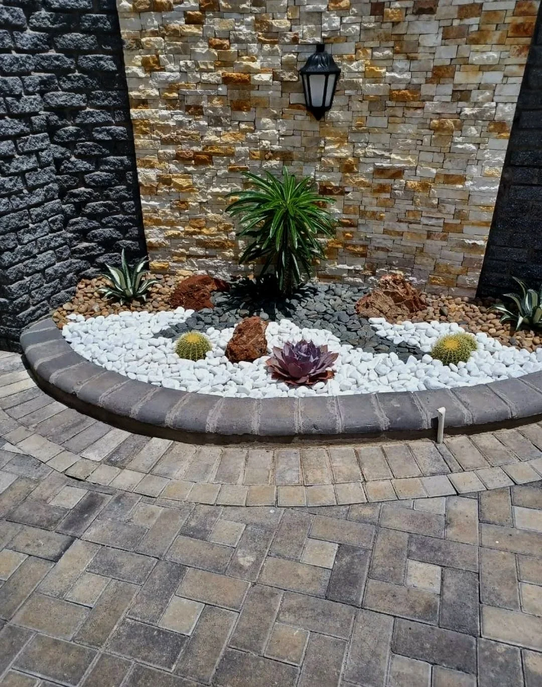A small landscaped garden with white and black pebbles.