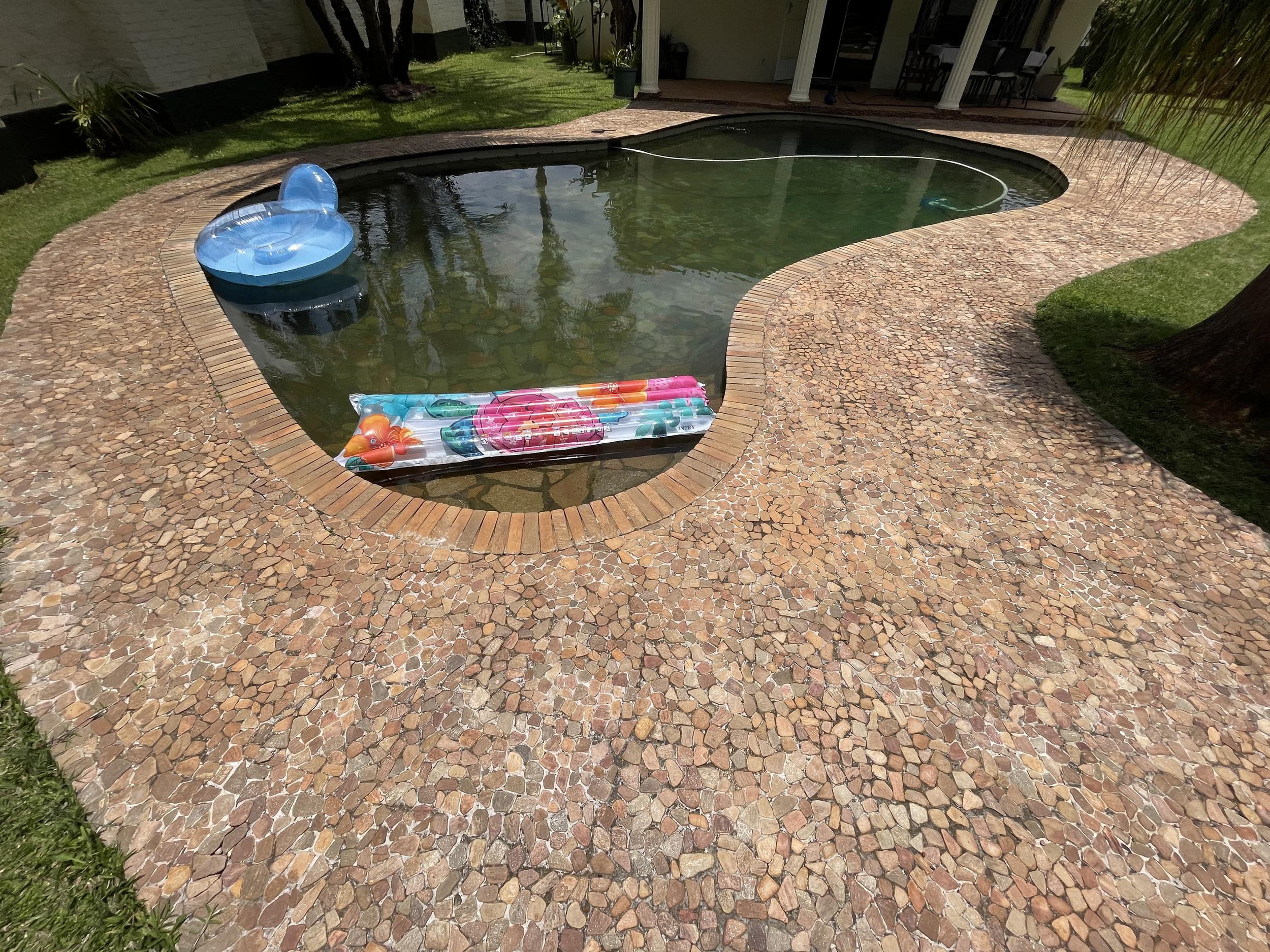 Pool surrounded by glitterstone pebbles.