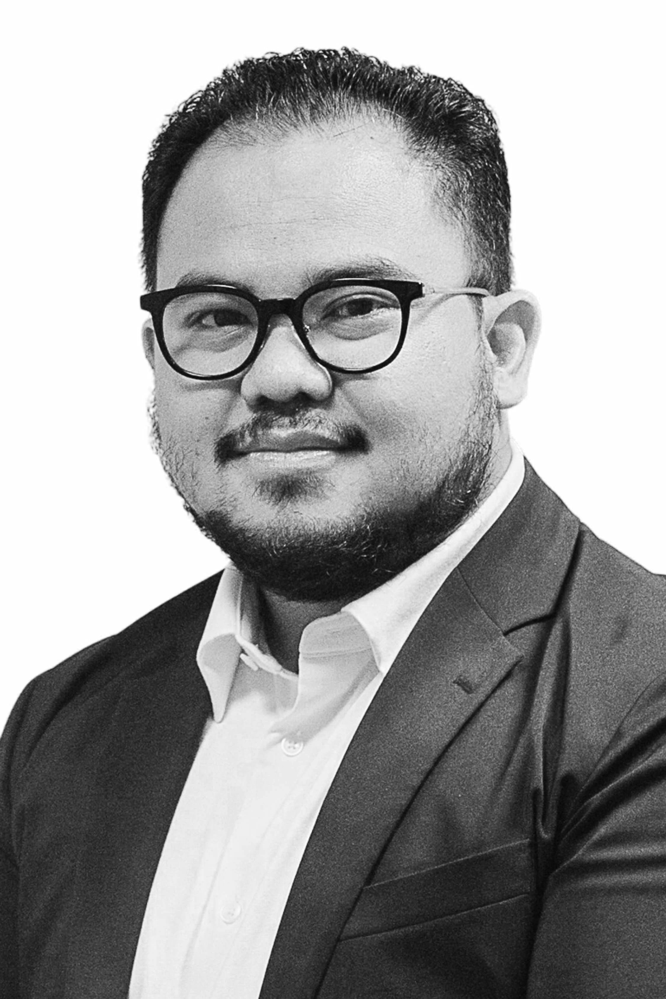 Black and white portrait of a man wearing glasses, a suit, and a white shirt, smiling slightly with a beard, against a plain background.