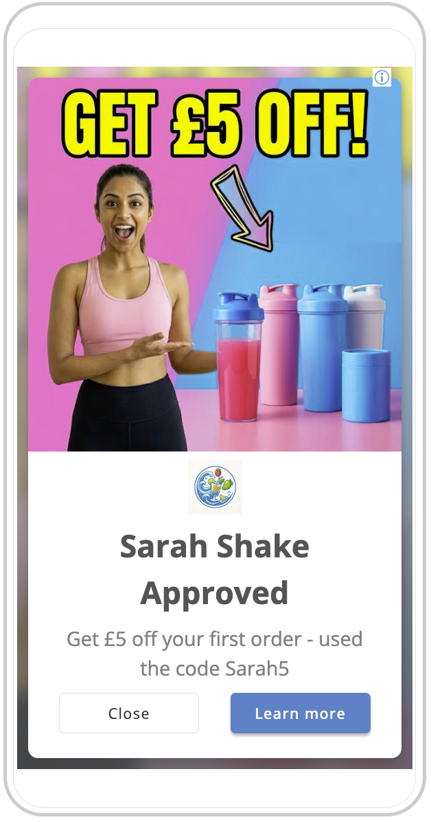 A woman smiling and pointing at a promotional display with water bottles in pink, blue, and white. The ad offers a 5-pound discount with the code Sarah5, and the text at the top reads 'GET £5 OFF!' in bold yellow letters.