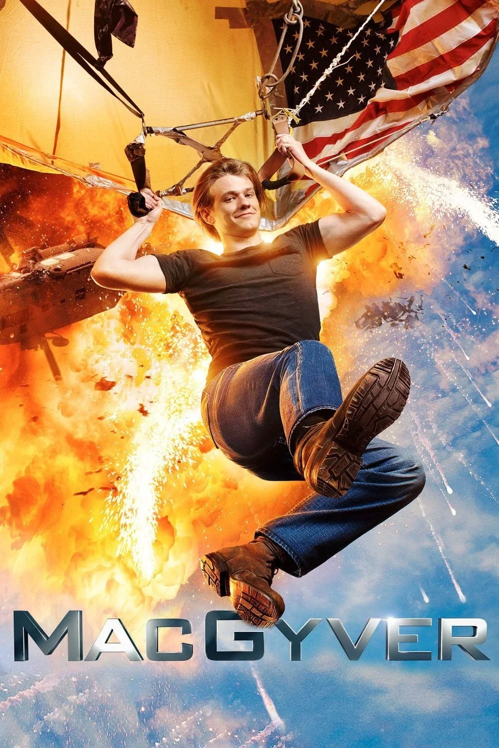 A young man in a black t-shirt and jeans is hanging from a hot air balloon with an American flag design, in front of an explosion and fire in the sky, with the name "MacGyver" in bold letters at the bottom.