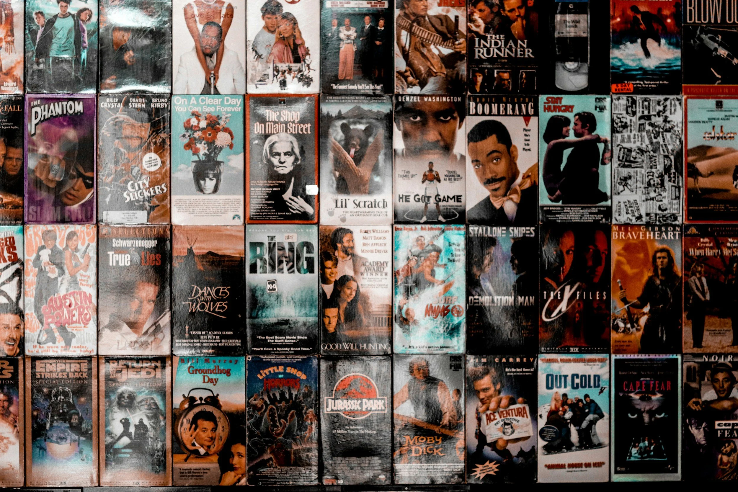 A collection of VHS tapes with movie and TV show covers, arranged in rows.