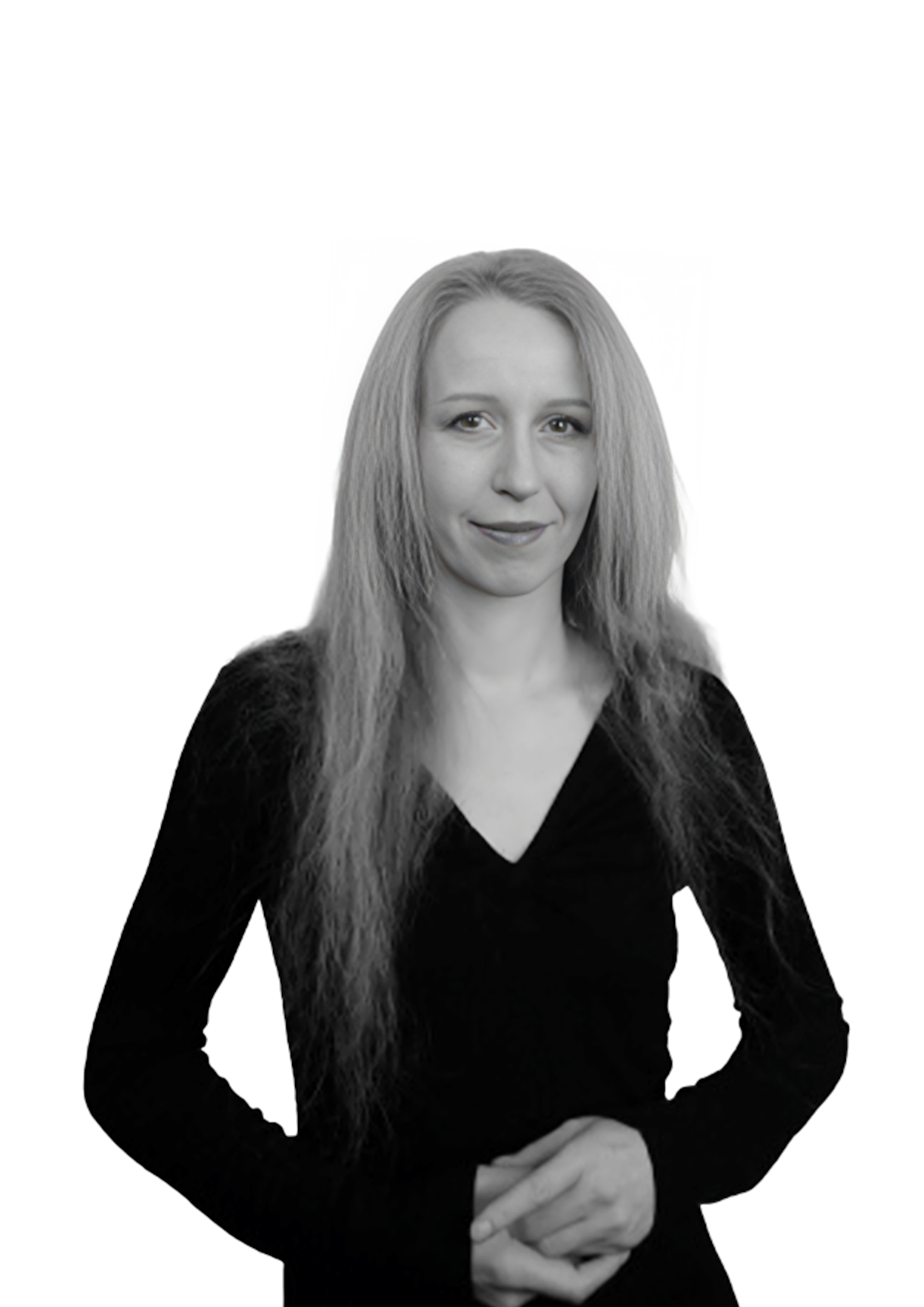 Black and white portrait of a woman with long, wavy hair, wearing a black V-neck top, standing against a plain white background.