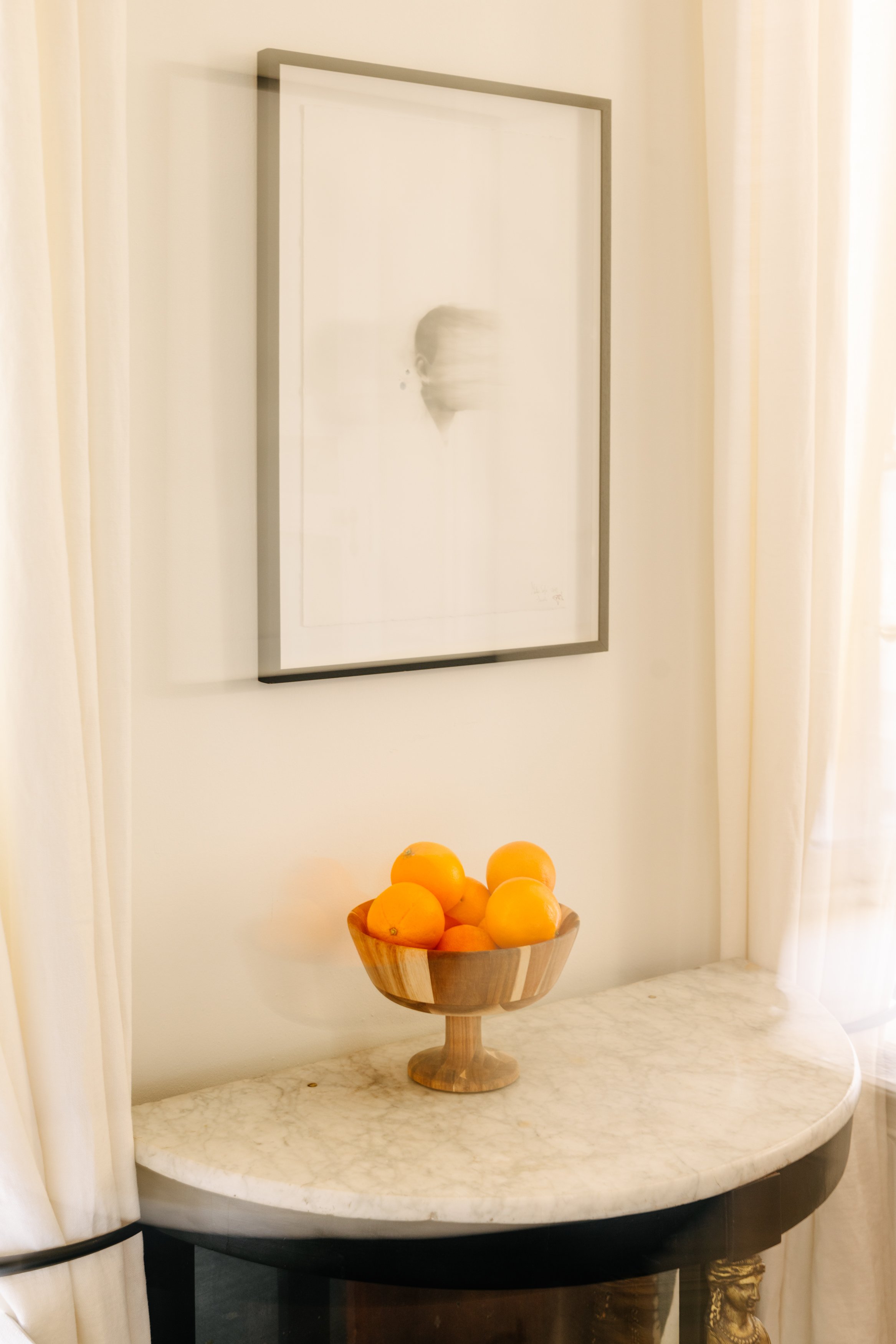 Pomme en bois sur une table en marbre avec un tableau abstrait blanc en arrière-plan