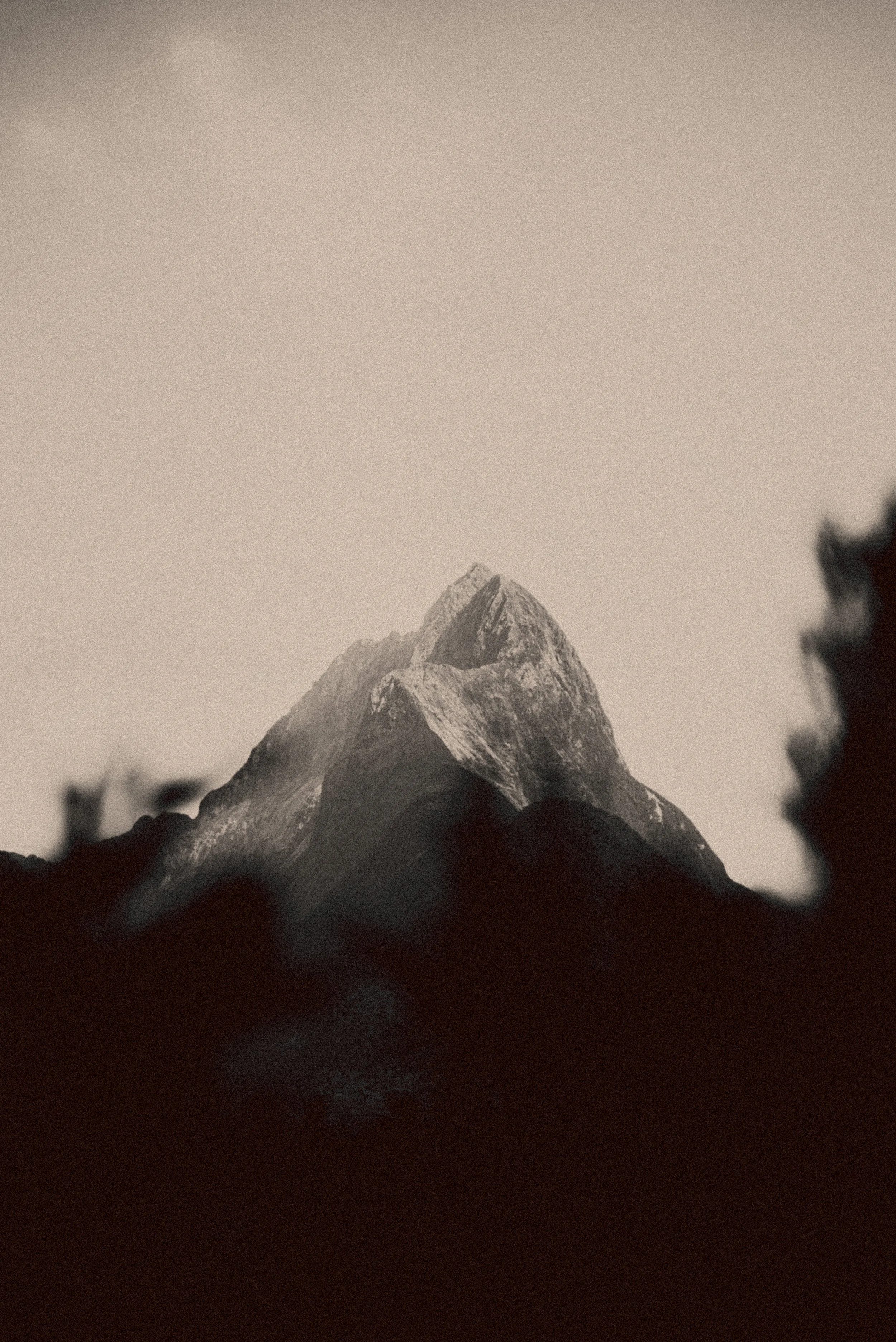 Photo d'une montagne enneigée vue de loin, en noir et blanc.