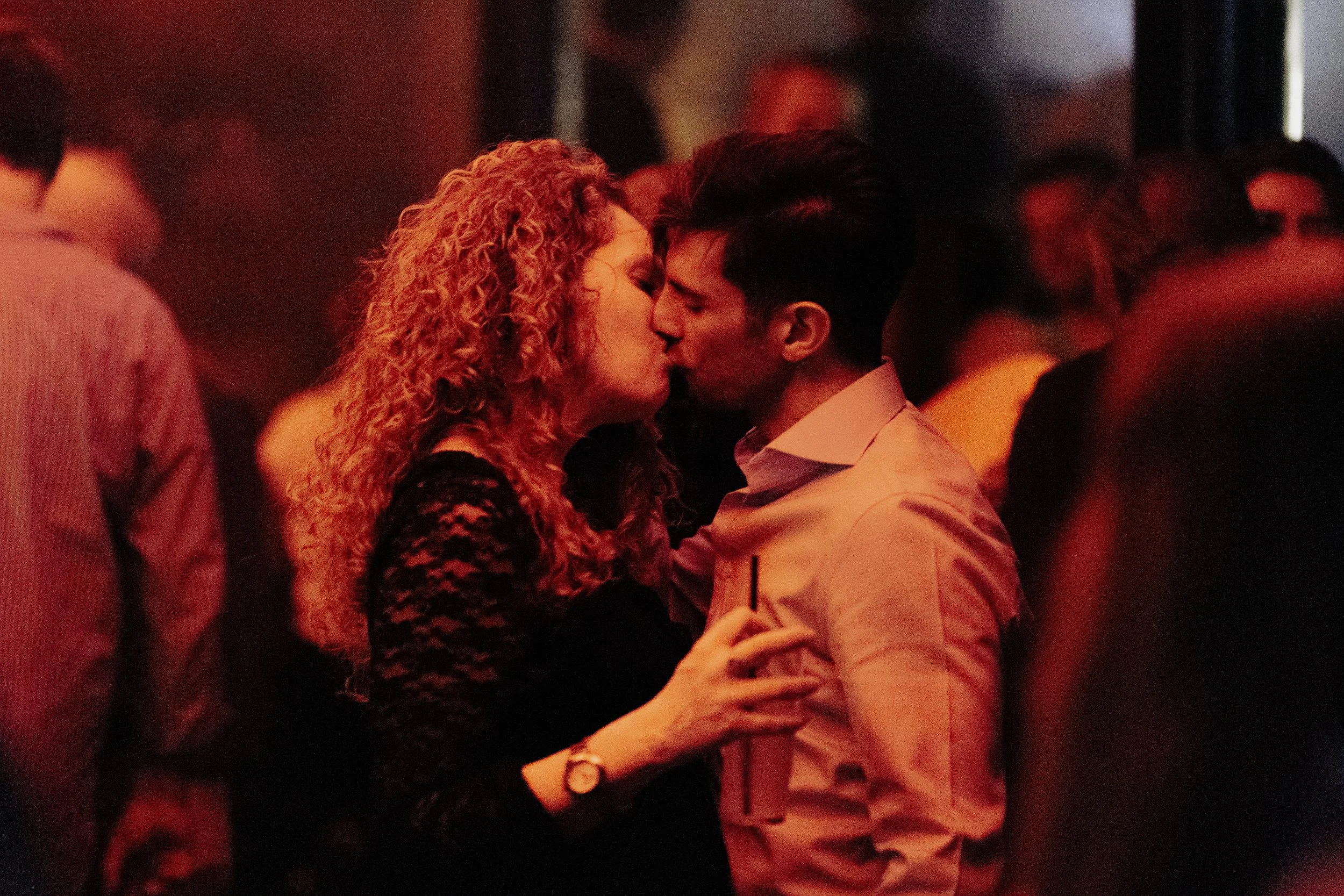 Un couple s'embrassant dans une ambiance sombre et chaleureuse.