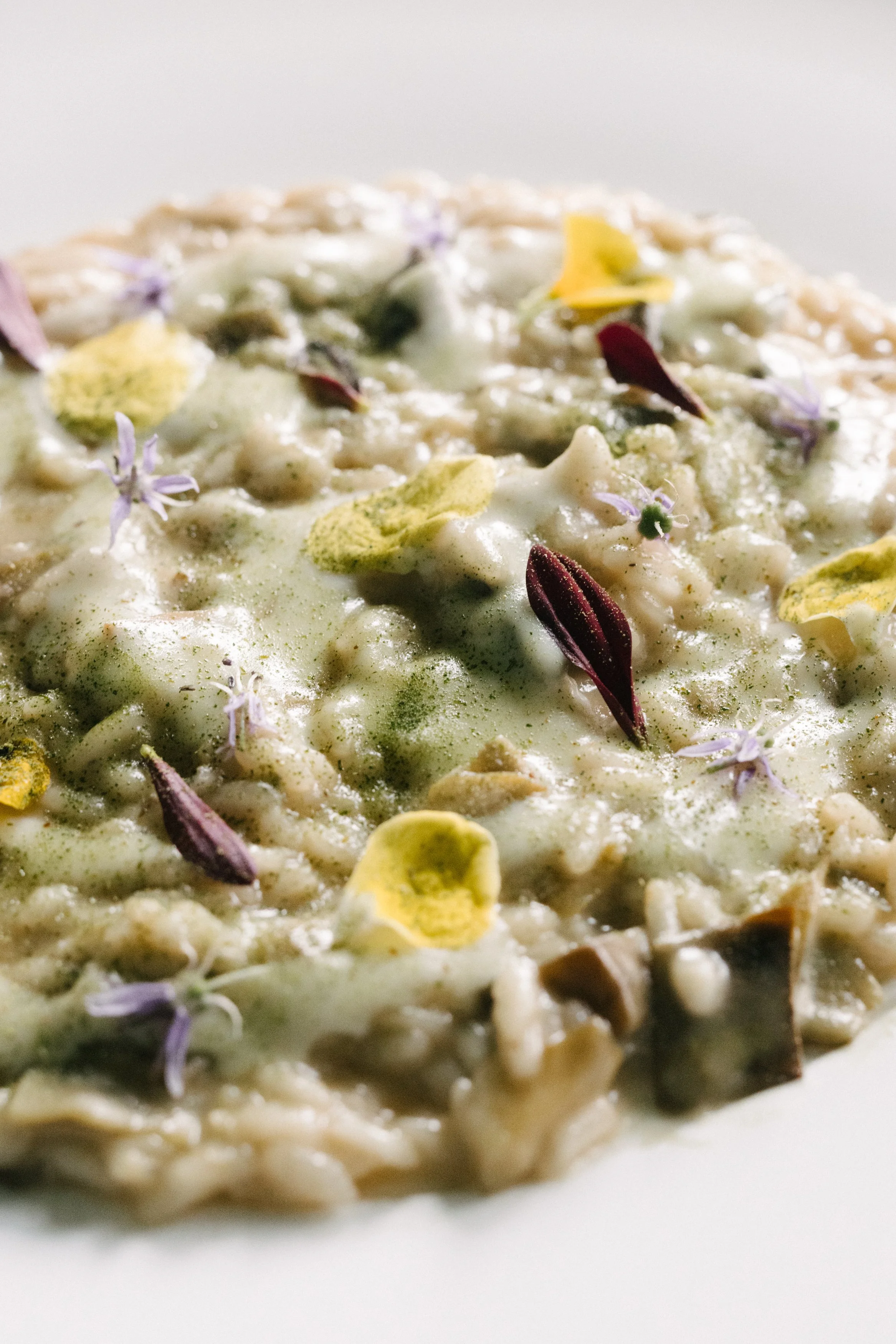Un plat de risotto garni de fleurs comestibles et d'épices.