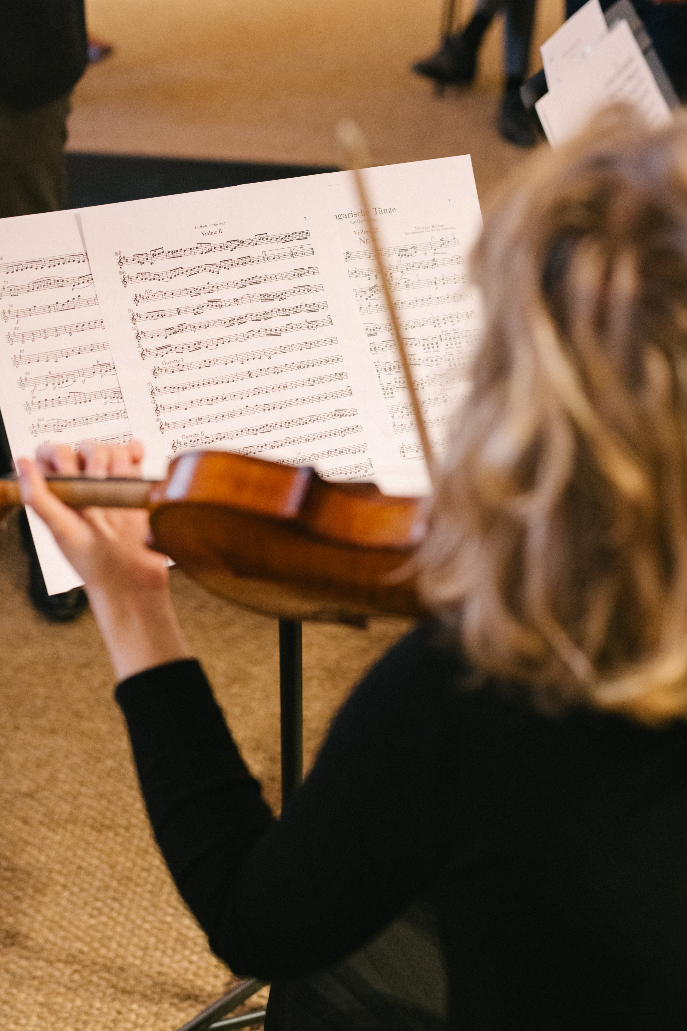 Une personne joue du violon lors d'une partition musicale dans une salle de concert.