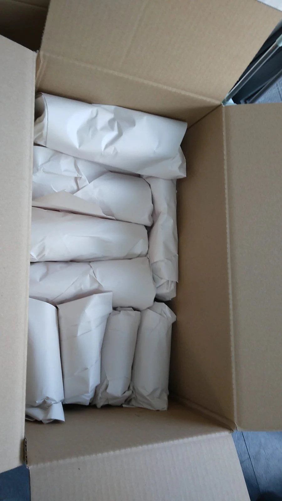 Open cardboard box containing wrapped packages.
