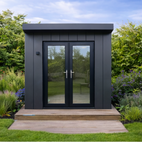 Garden Room Frame finished  with glass double doors on a wooden platform, surrounded by green bushes and plants, under a partly cloudy sky.