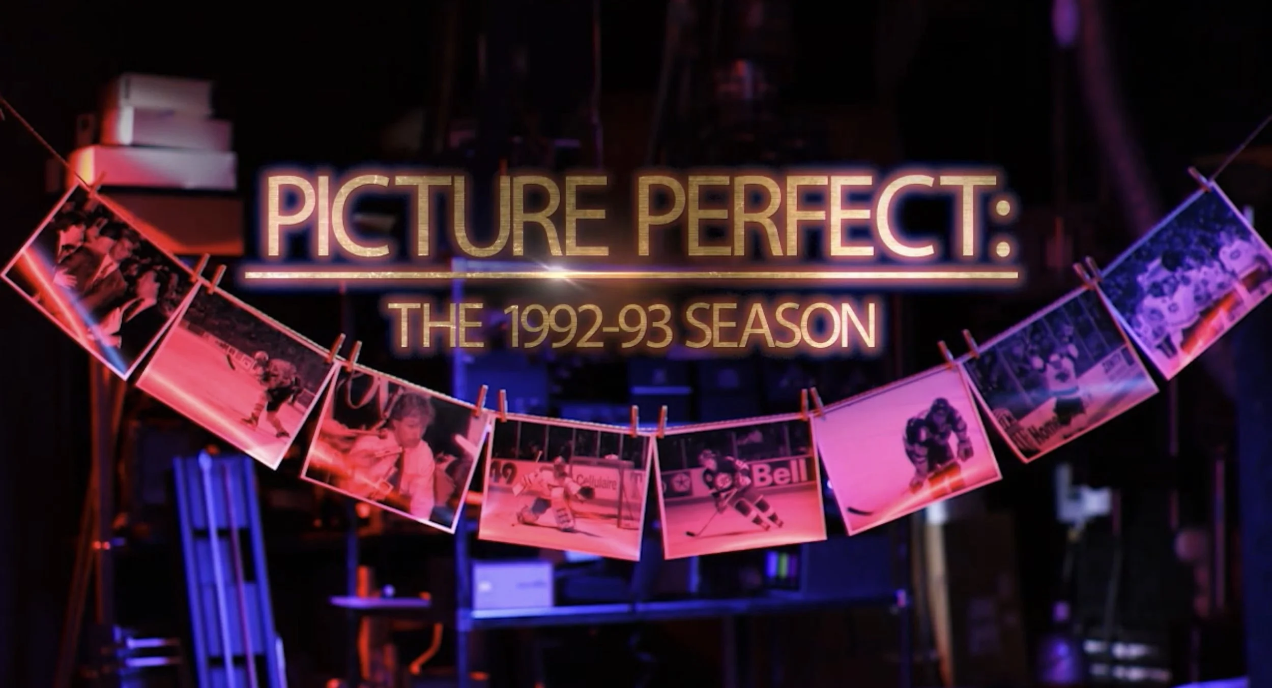 A neon sign reads 'Picture Perfect: The 1992-93 Season' in front of a dark background, with images of ice hockey players hanging on a string with clothespins below the sign.