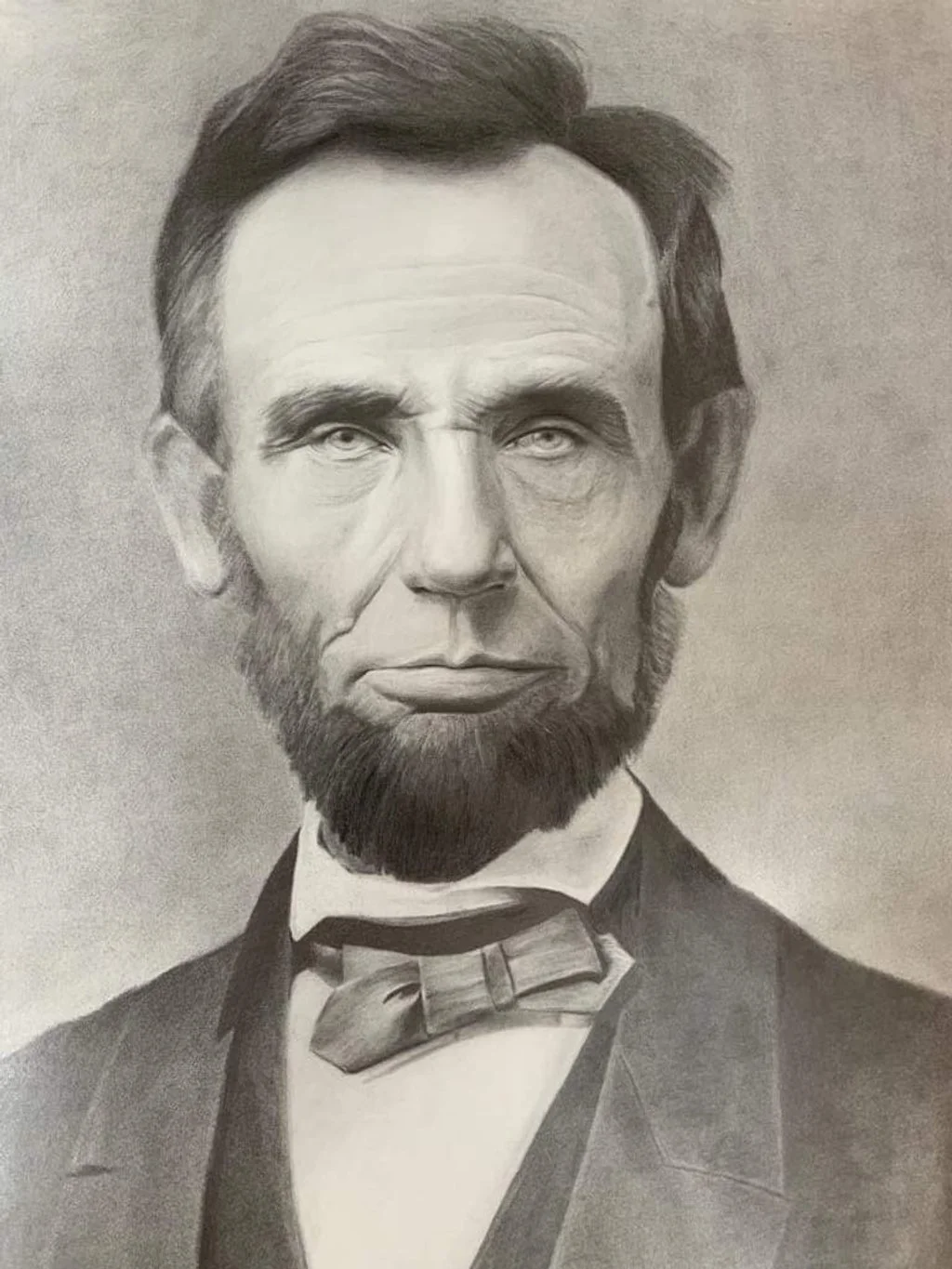 A detailed black and white pencil sketch of Abraham Lincoln with a beard, wearing a tuxedo and bow tie.