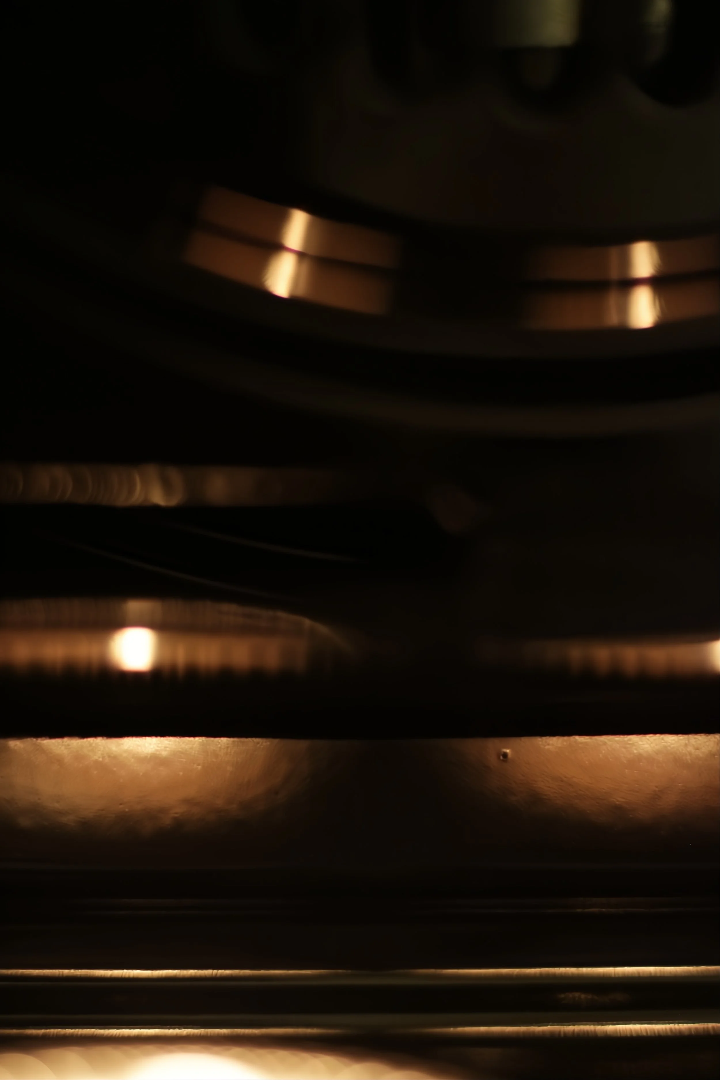Close-up of a metallic mechanical guitar pedal with warm lighting.