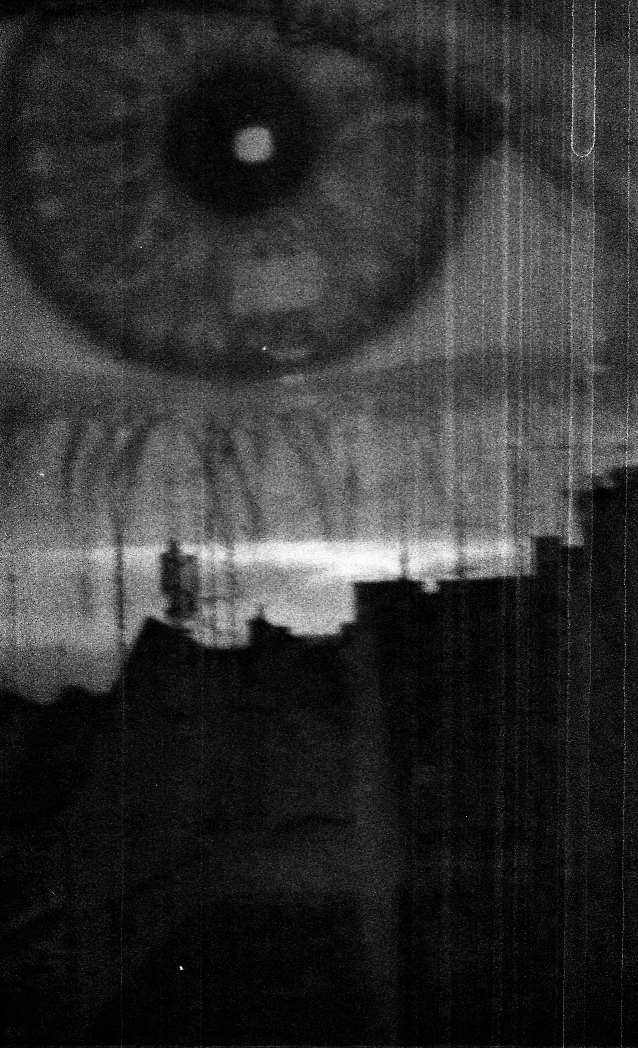 Close-up of a person's eye with visible eyelashes, in black and white, with a grainy texture.
