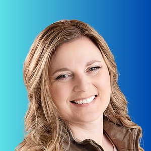 Portrait of a smiling woman with wavy hair against a blue gradient background.