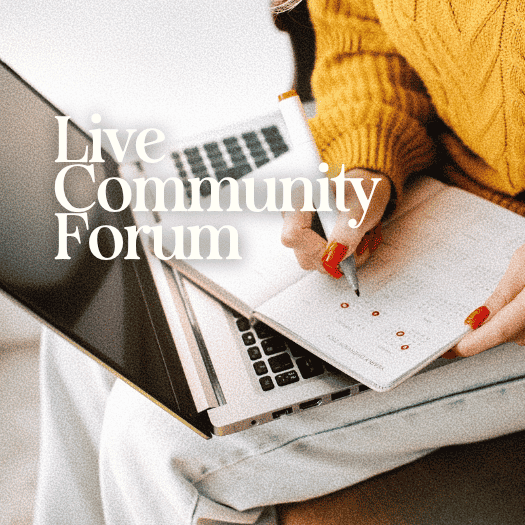 Person in yellow sweater writing in a notebook with a laptop open nearby during a community forum.