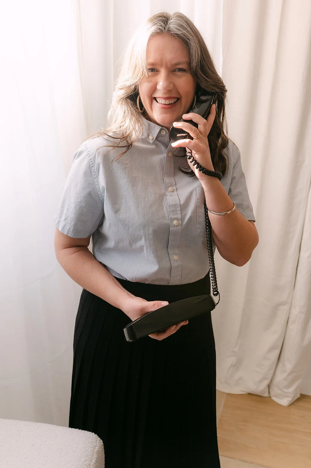 Photo of Rachel Duncan, sitting, hands clasped leaning forward and smiling