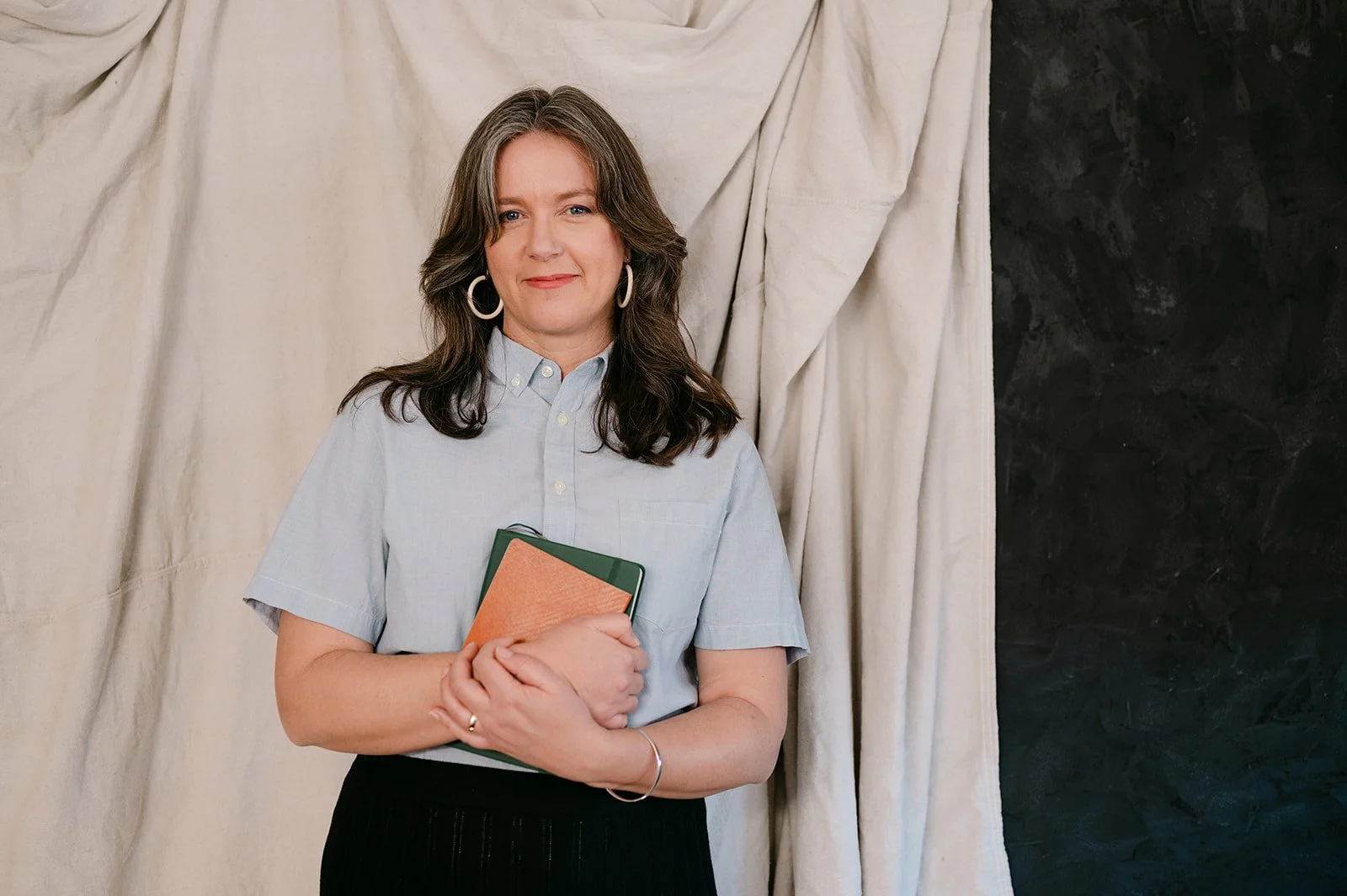 Rachel holding books, smiling at the camera