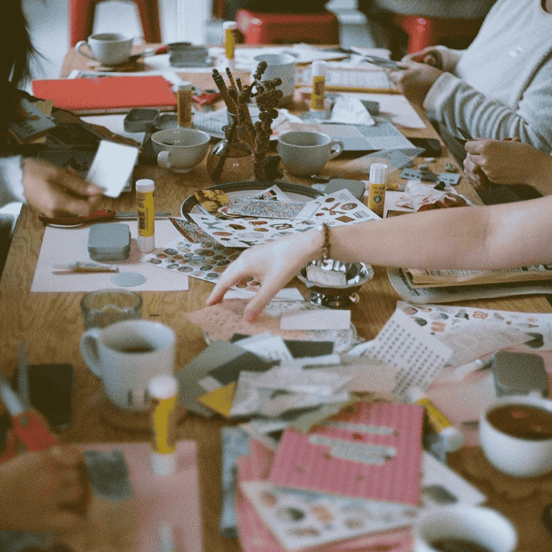 a group of women are crafting at a table with various art supplies