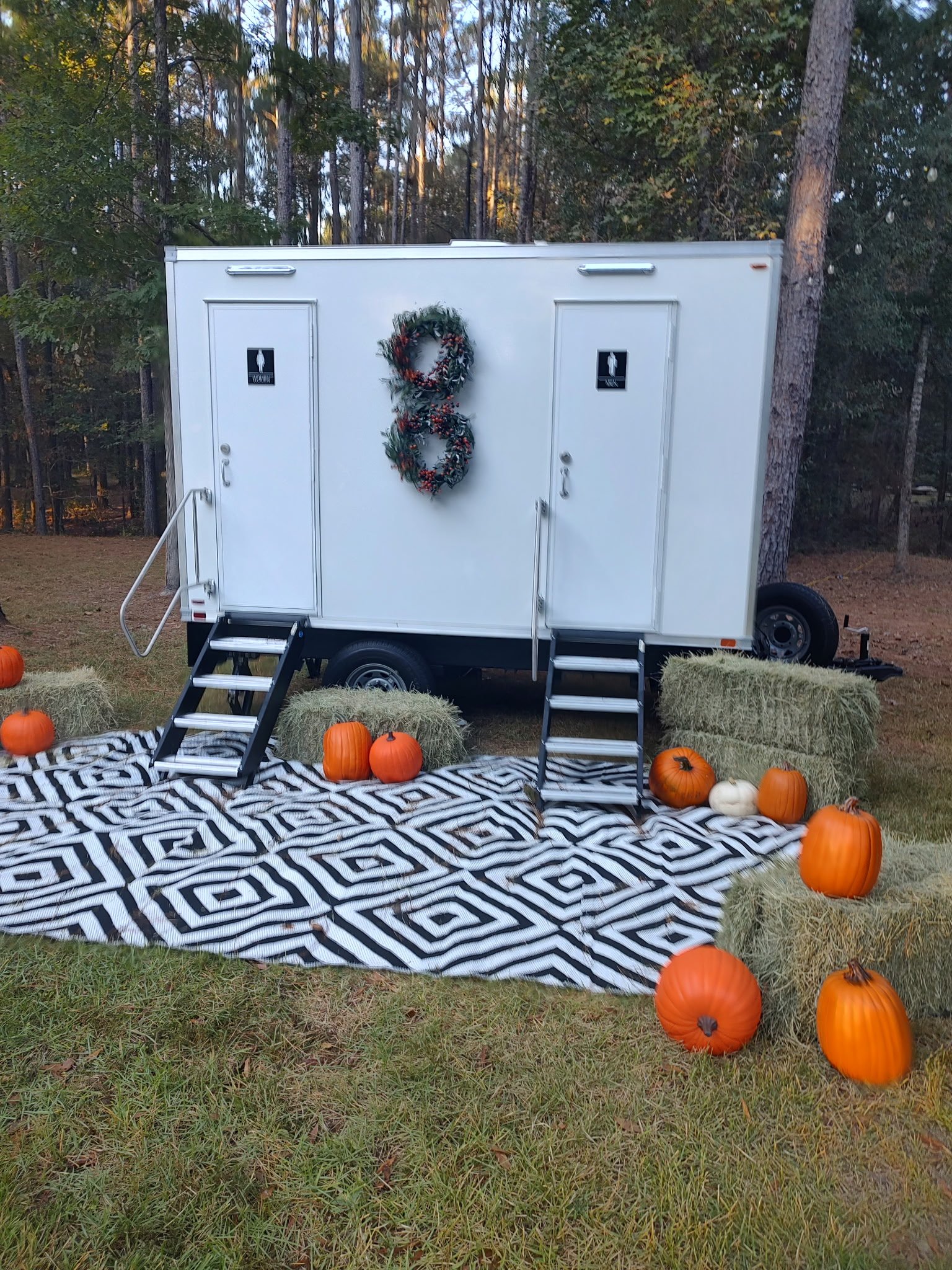 2 stall restroom trailer decorated for a fall party.