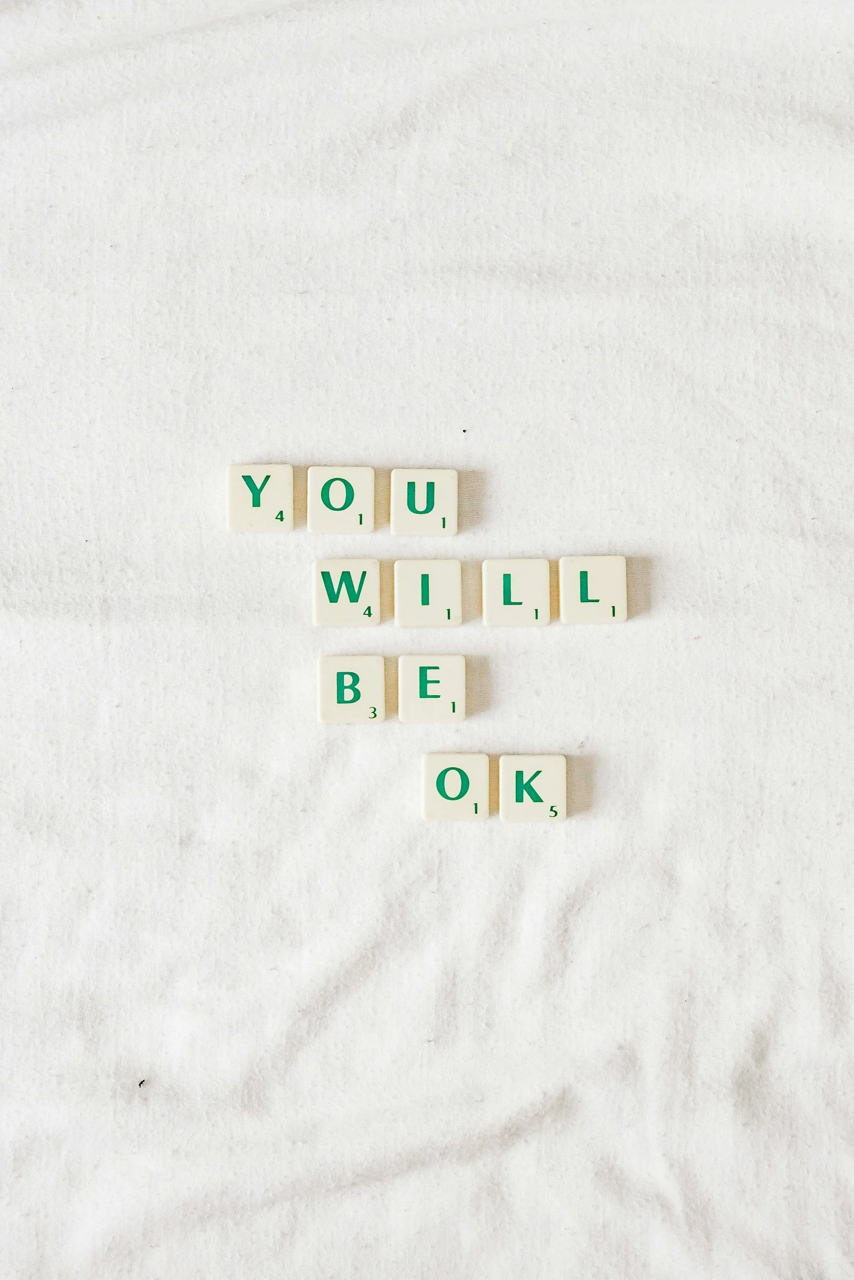 Scrabble tiles spelling out "You will be OK" on a white background.