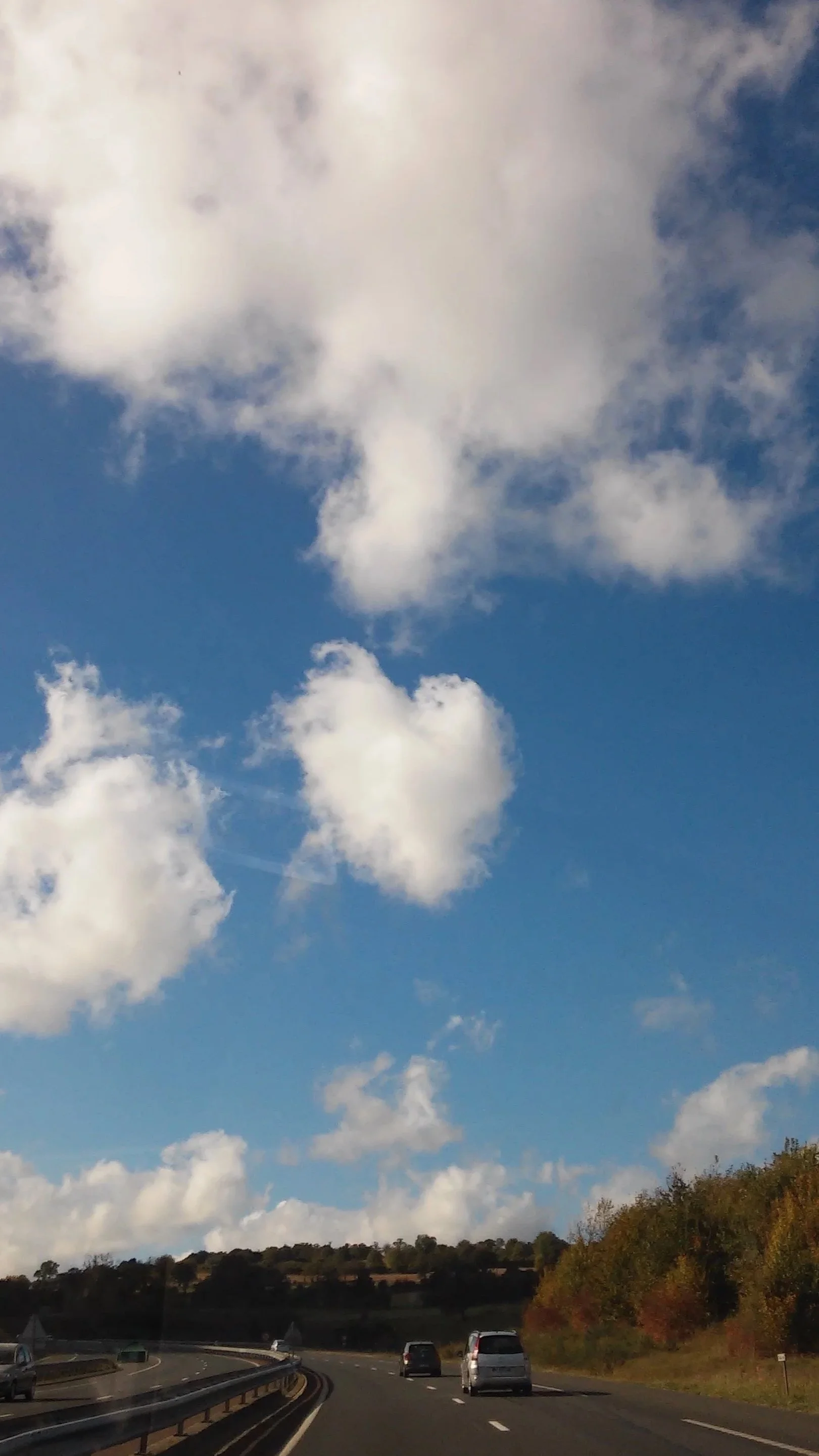 Strada in autostrada con auto e paesaggio collinare e cielo con nuvole