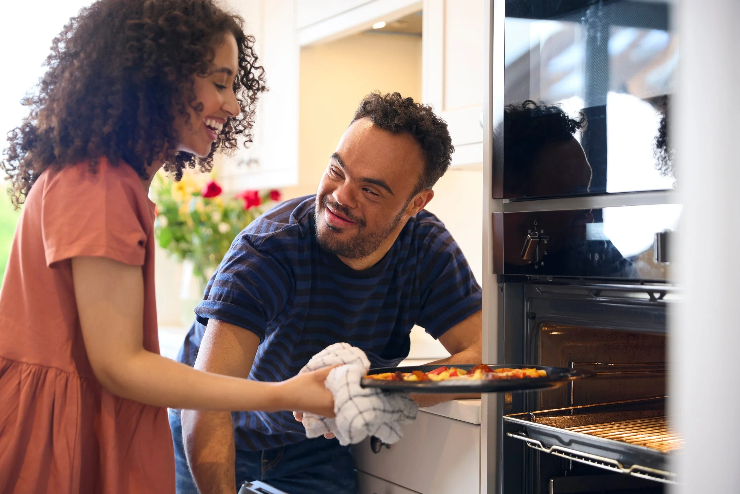 TBI residents practicing daily living skills together in a Medical Alternatives community home in Southeast Michigan