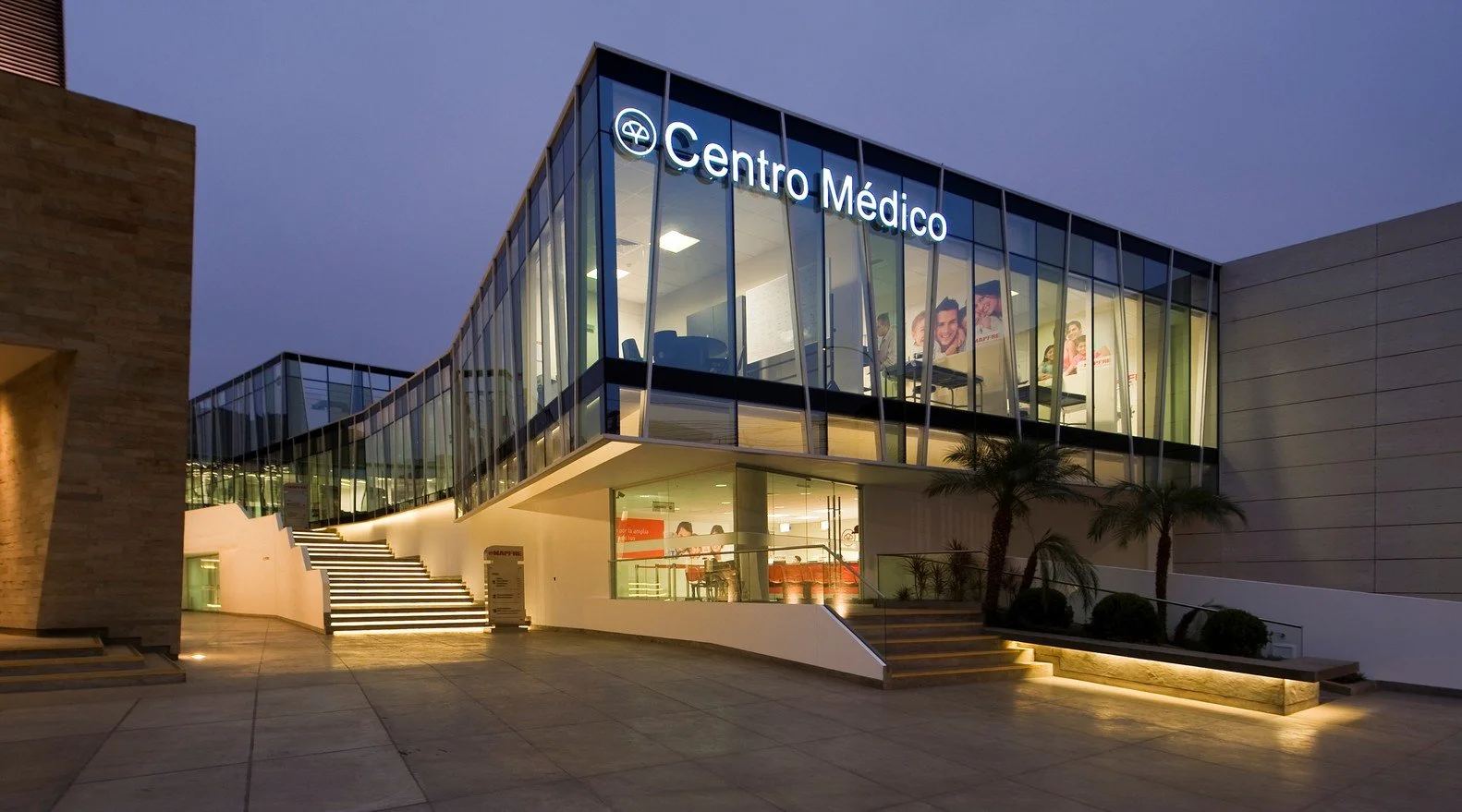 Edificio de un centro médico con estructura moderna de vidrio y luces