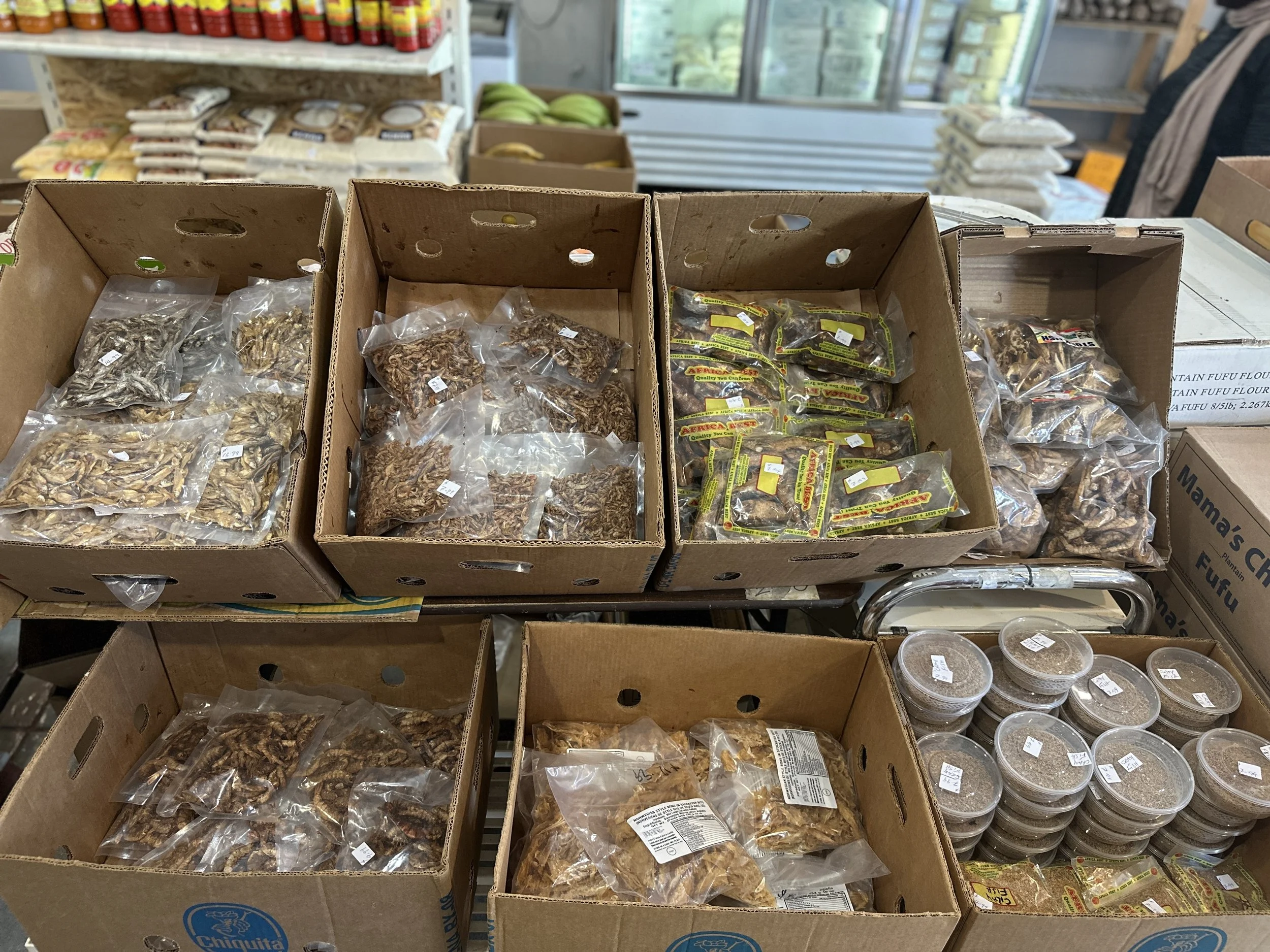 Various packages of dried nuts and snacks in cardboard boxes on a store display table.
