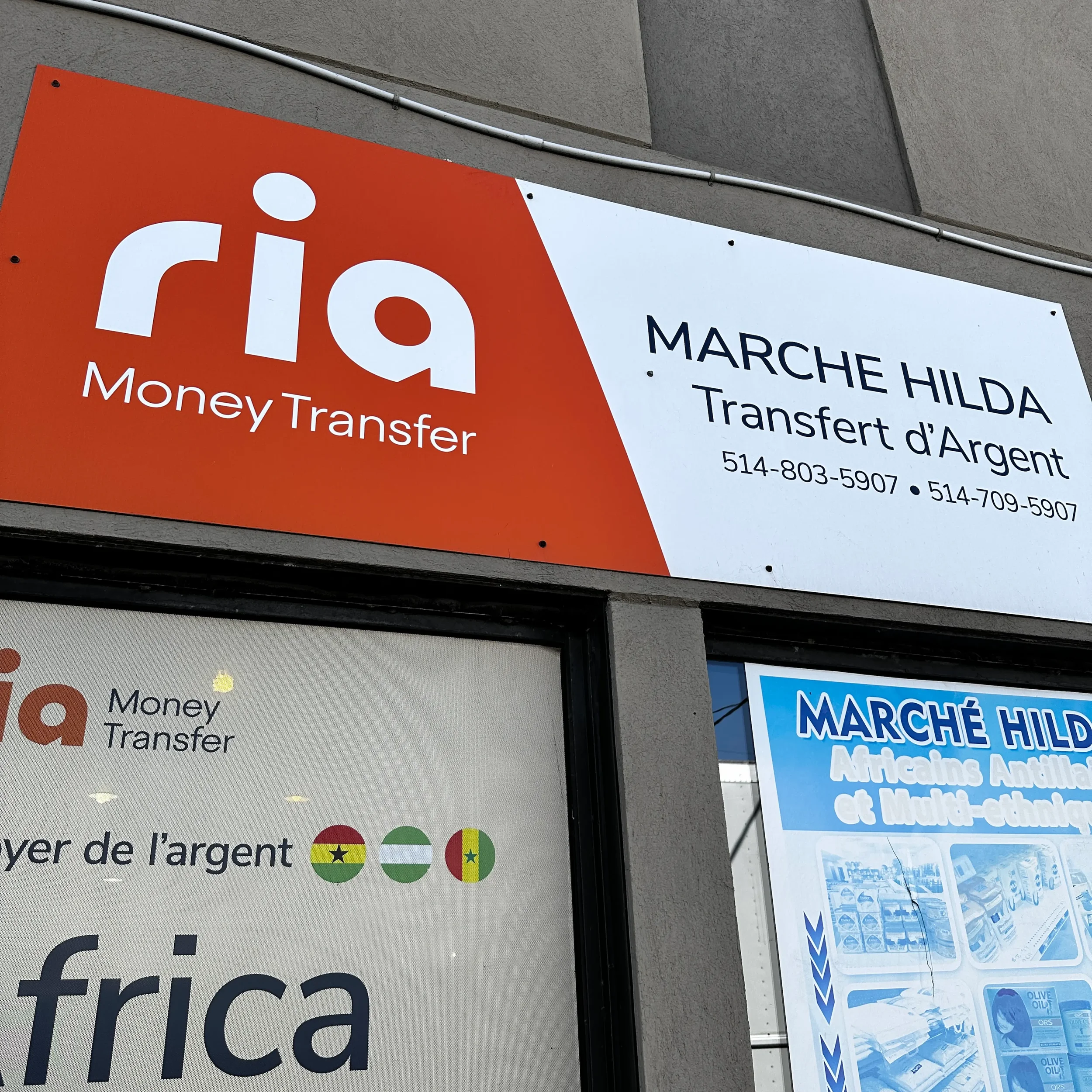 Sign for Rio Money Transfer and Marché Hilda, a currency exchange business with contact numbers, next to a window with flags of Ghana, Nigeria, and Senegal indicating currency services for Africa.