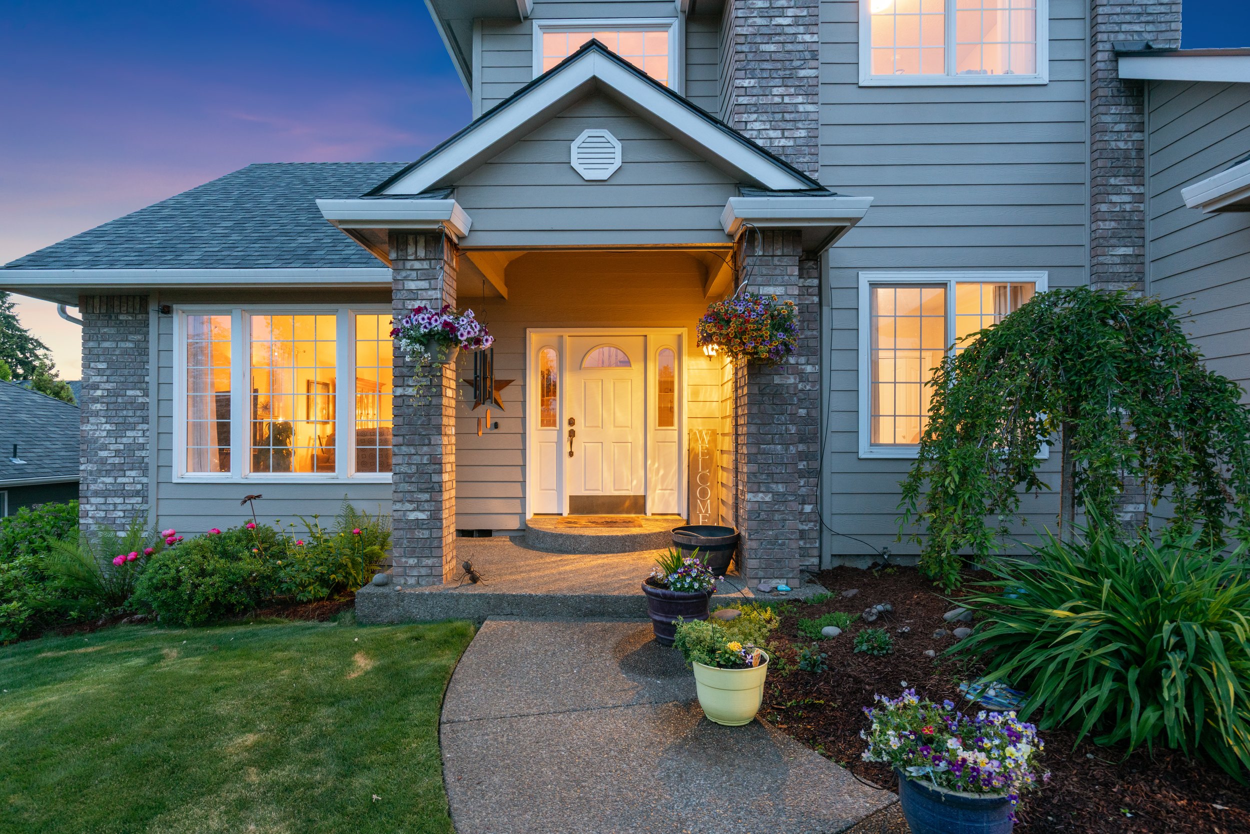 Twilight real estate photography of a home exterior with warm interior lighting at dusk